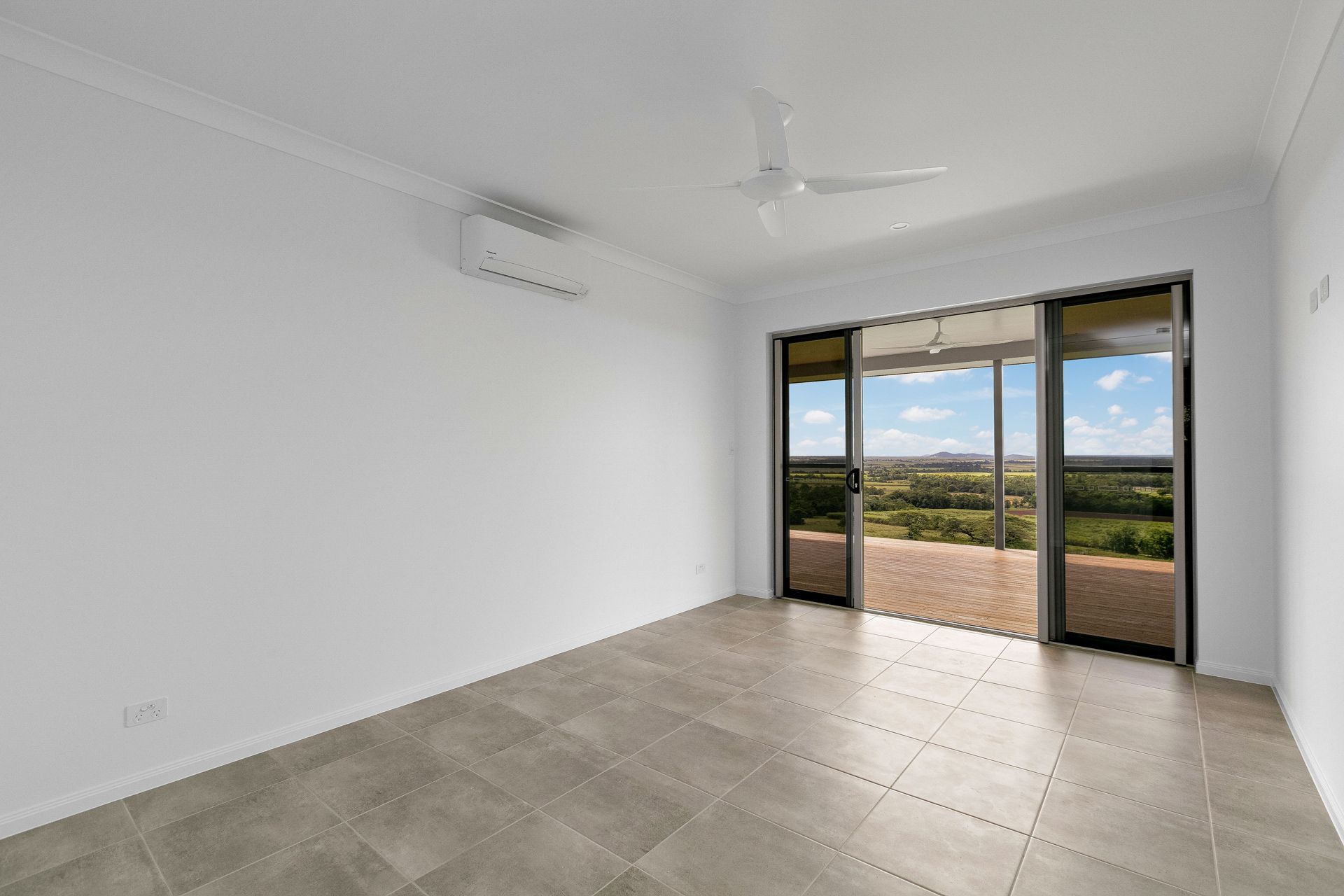 A Bright, Empty Room With Light Gray Tile Floors — Ashlee Jones Homes in Gordonvale, QLD