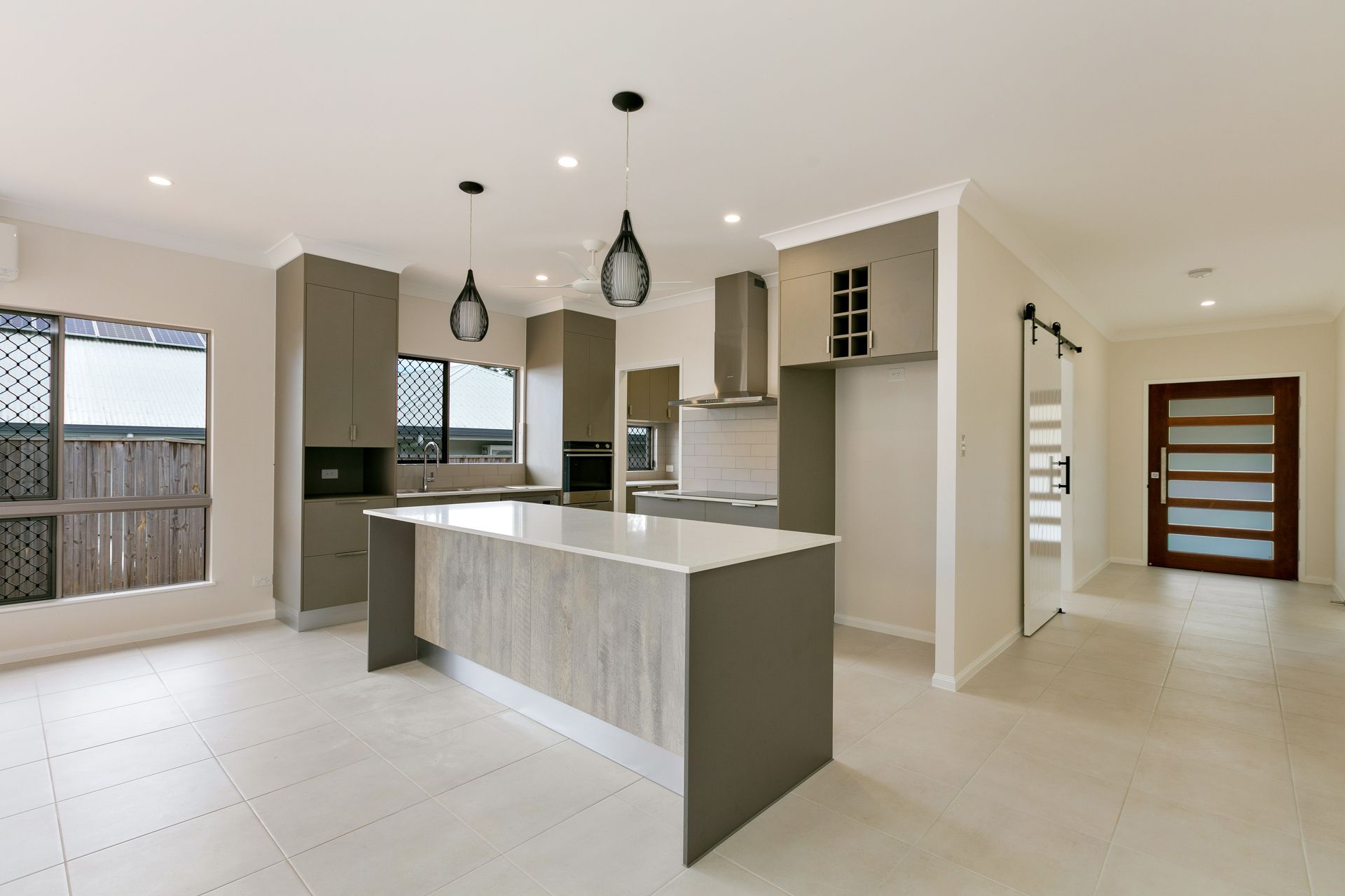 A Modern, Open-plan Kitchen With a Grey and Wood-tone Island — Ashlee Jones Homes in Gordonvale, QLD