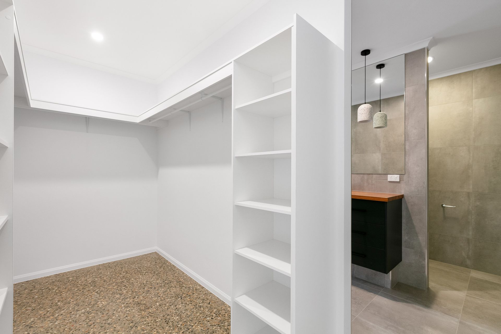 A Walk-in Closet With White Walls and Shelving — Ashlee Jones Homes in Gordonvale, QLD