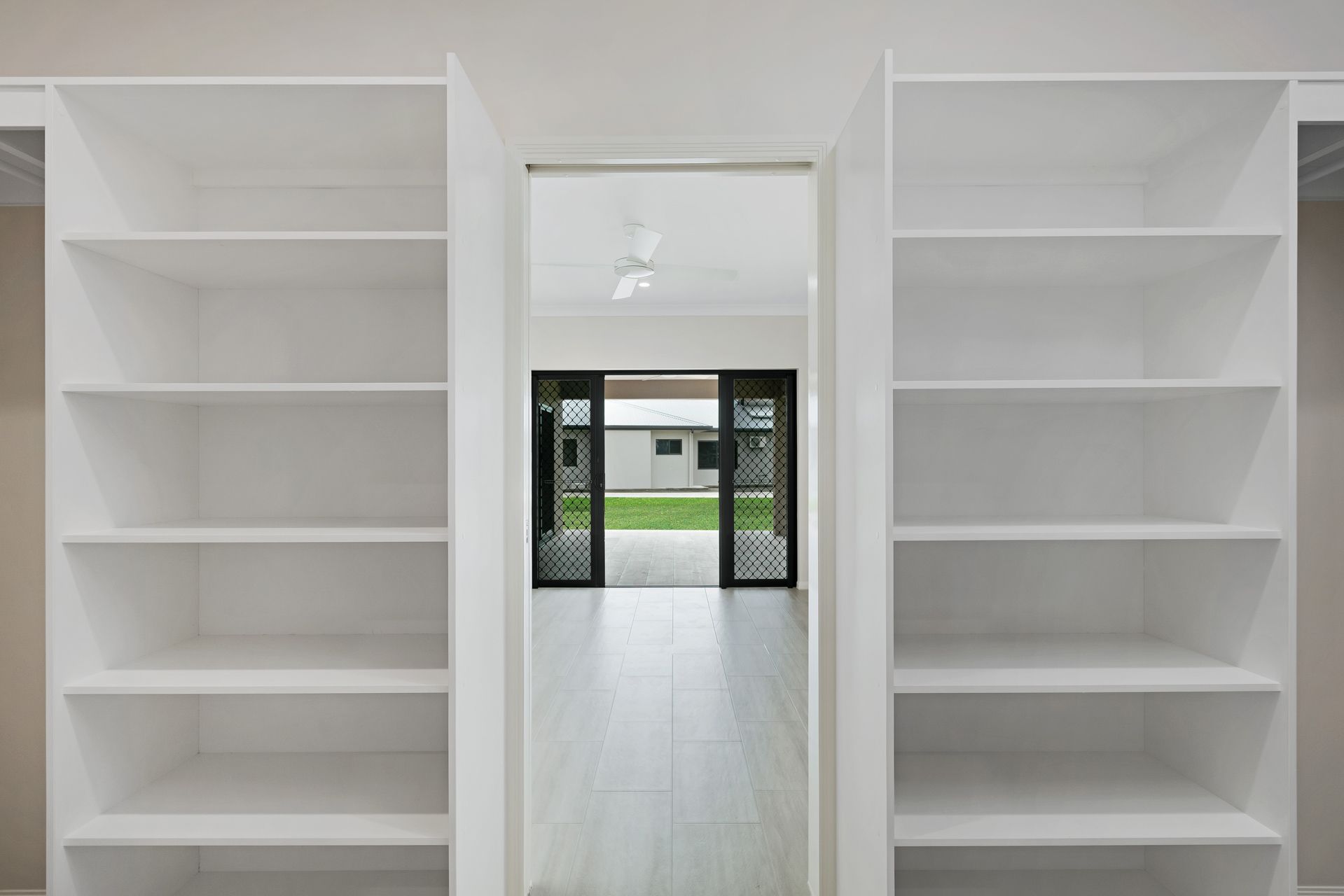 Two White, Multi-shelf Storage Units Flank a Doorway — Ashlee Jones Homes in Gordonvale, QLD