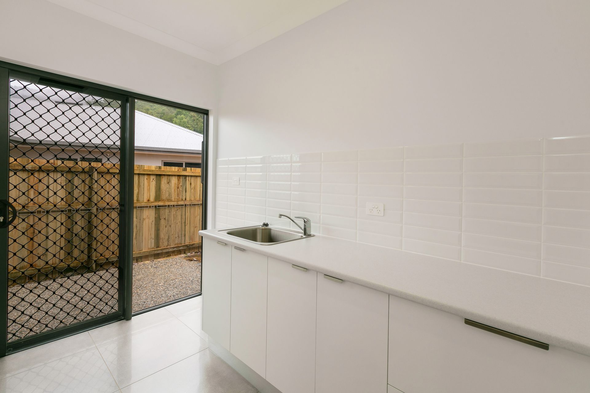 A Modern Kitchen Featuring White Cabinets — Ashlee Jones Homes in Gordonvale, QLD