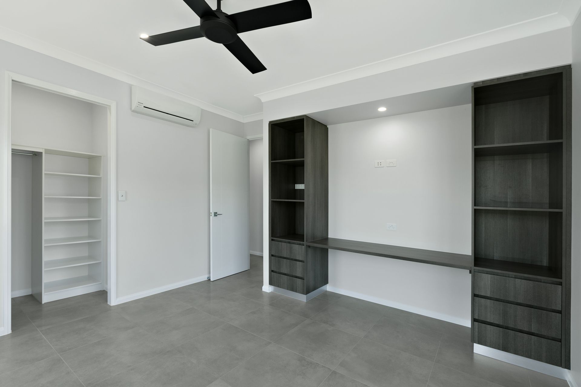 A Modern, Empty Room Featuring a Dark Grey Desk Unit — Ashlee Jones Homes in Gordonvale, QLD