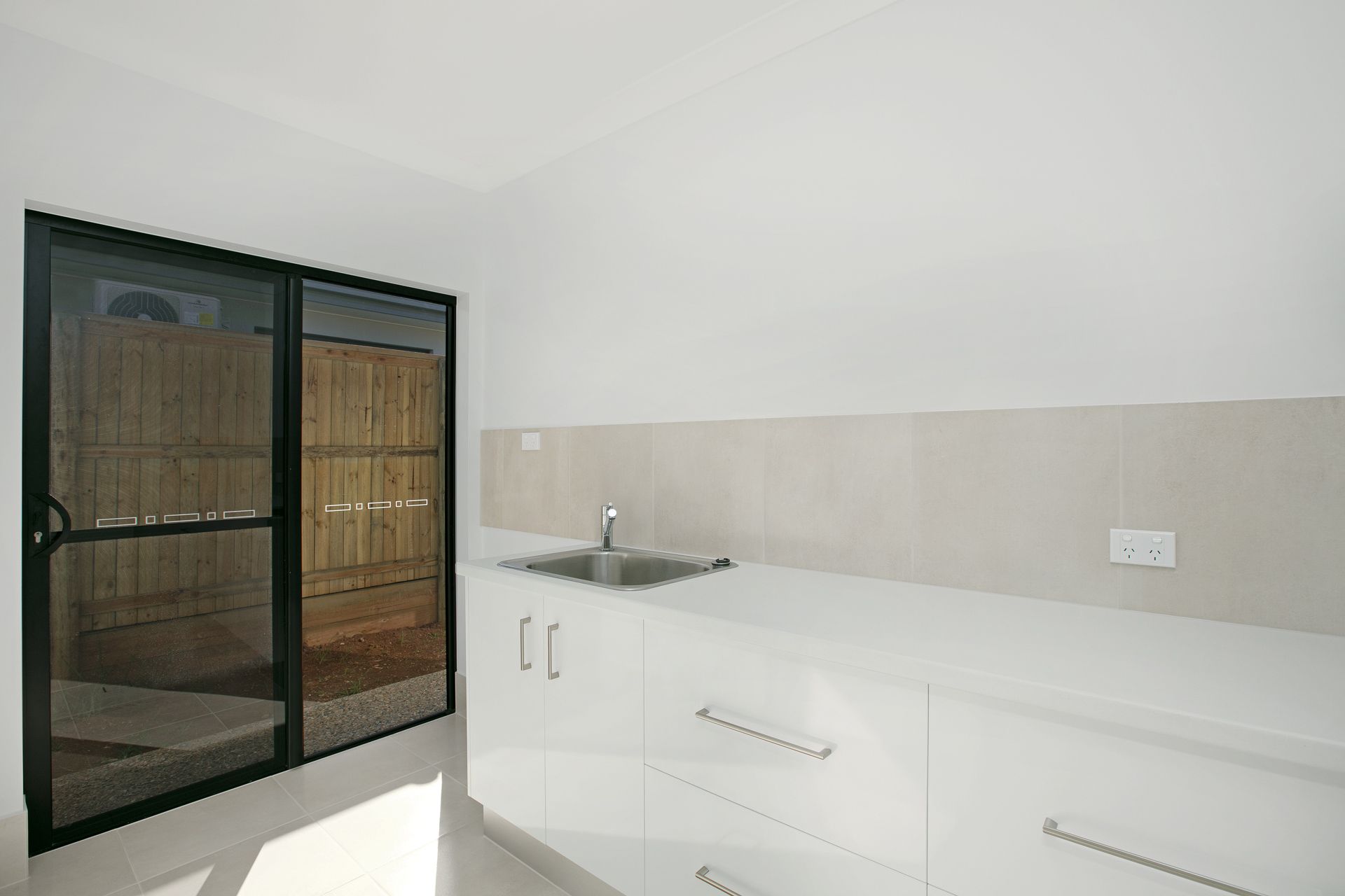 A Bright, Modern Kitchenette Featuring White Cabinetry — Ashlee Jones Homes in Gordonvale, QLD