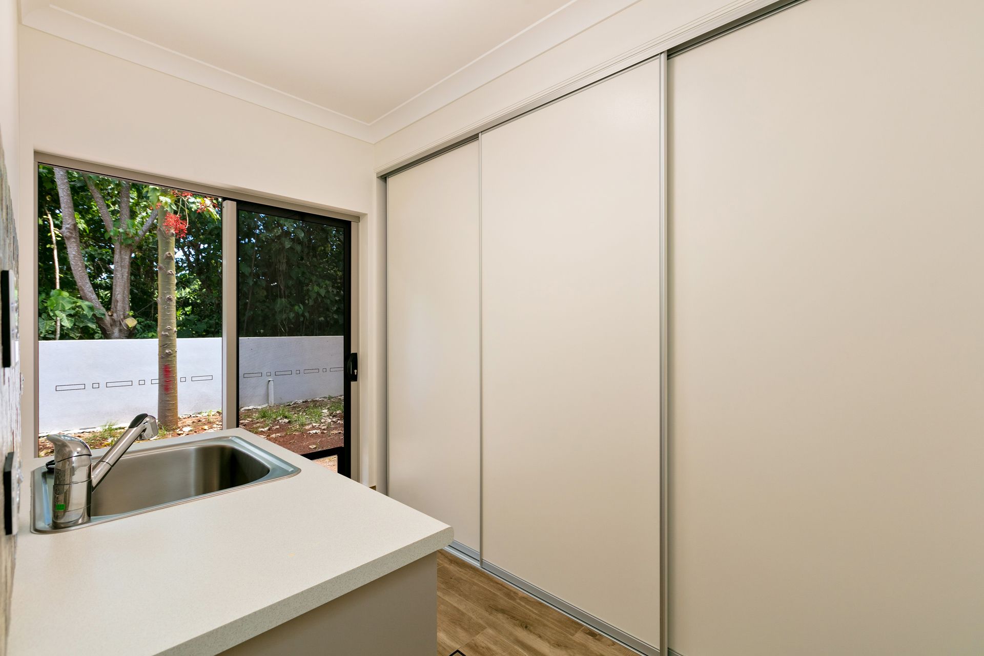 A Kitchen Sink Counter Next to Sliding Closet Doors — Ashlee Jones Homes in Gordonvale, QLD