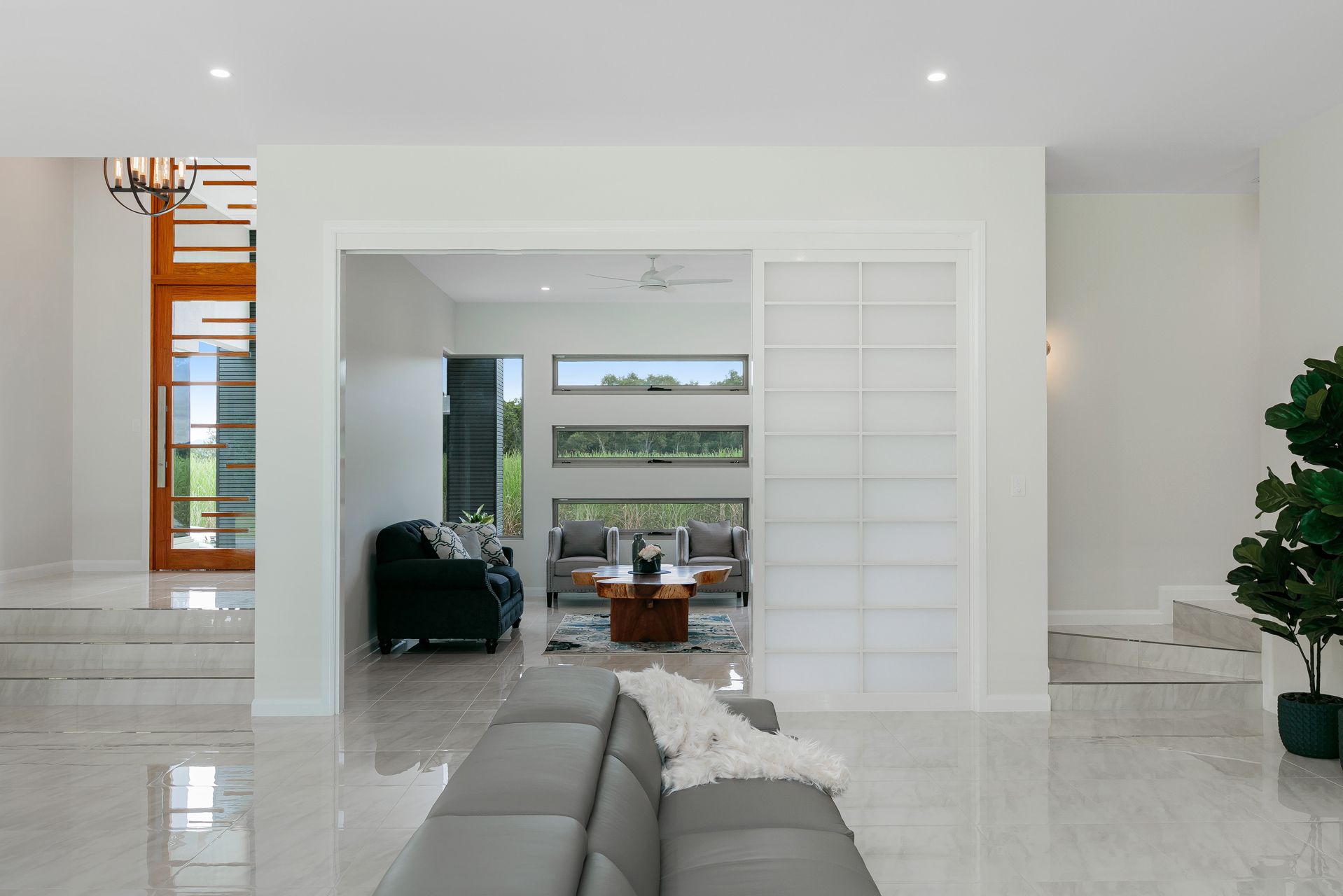 A Modern, White Interior View Showing a Living Area Through a Wide Doorway — Ashlee Jones Homes in Gordonvale, QLD
