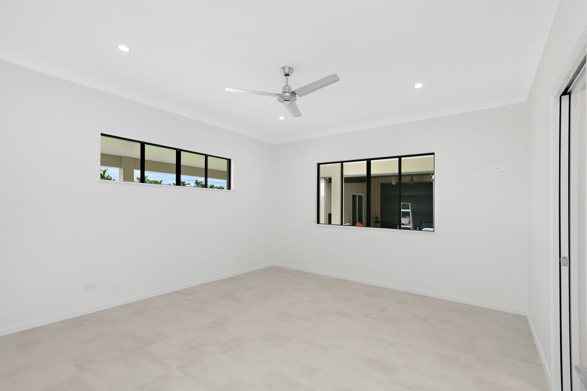 A White, Modern Empty Room Featuring a Ceiling Fan — Ashlee Jones Homes in Gordonvale, QLD