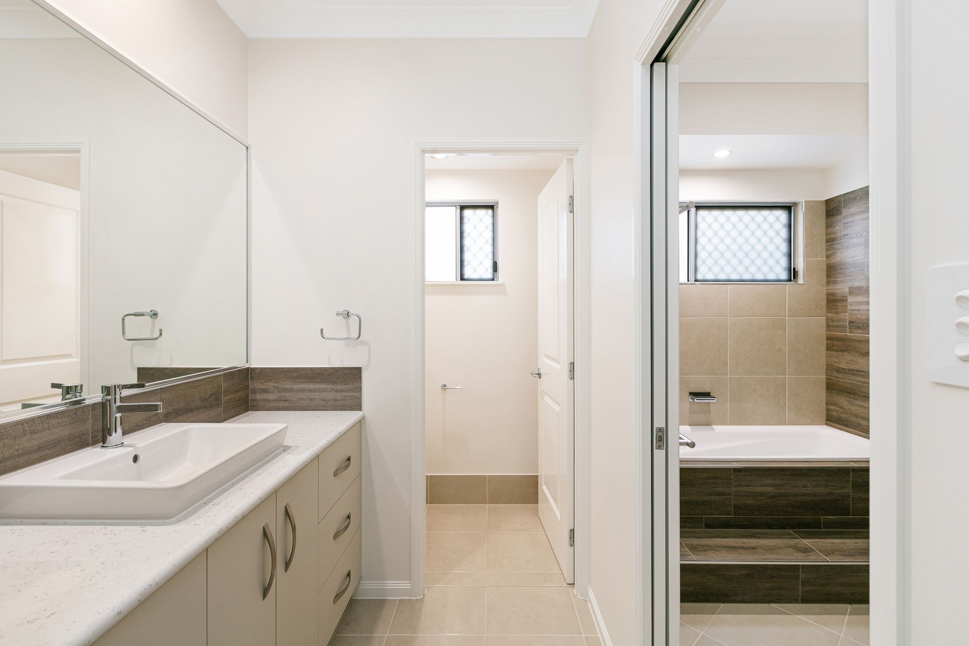A Modern Bathroom Featuring a White Vanity With a Rectangular Sink — Ashlee Jones Homes in Gordonvale, QLD