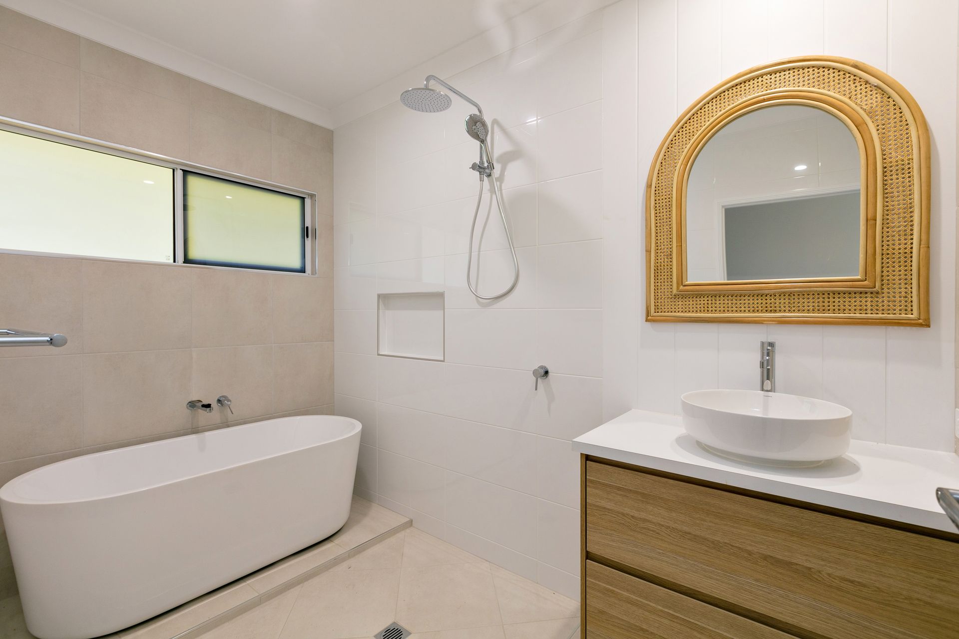 A Bright Bathroom Featuring a White Freestanding Bathtub — Ashlee Jones Homes in Gordonvale, QLD