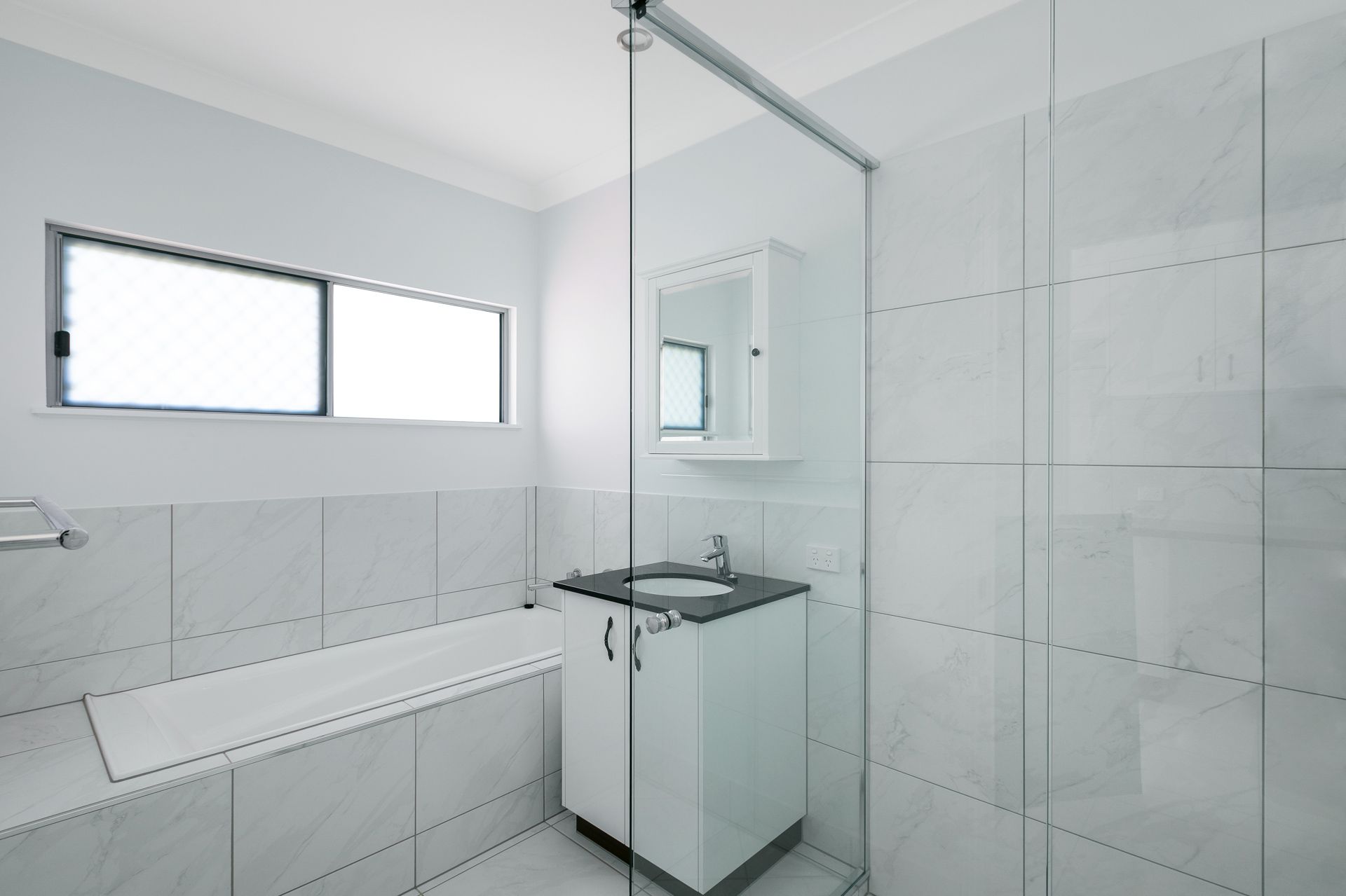 Modern White Bathroom With a Built-in Bathtub — Ashlee Jones Homes in Gordonvale, QLD
