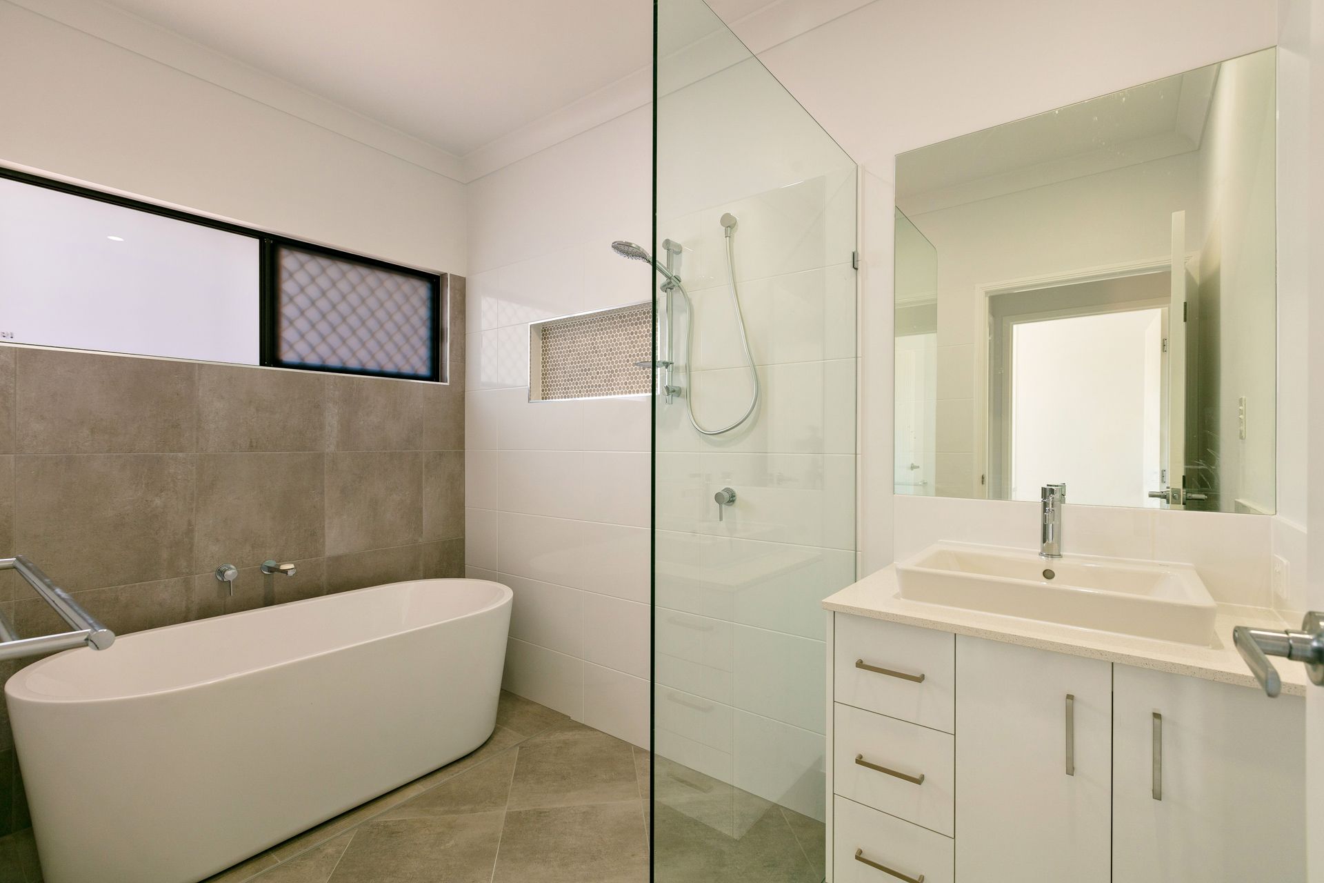 Modern Bathroom Featuring a White Freestanding Bathtub — Ashlee Jones Homes in Gordonvale, QLD