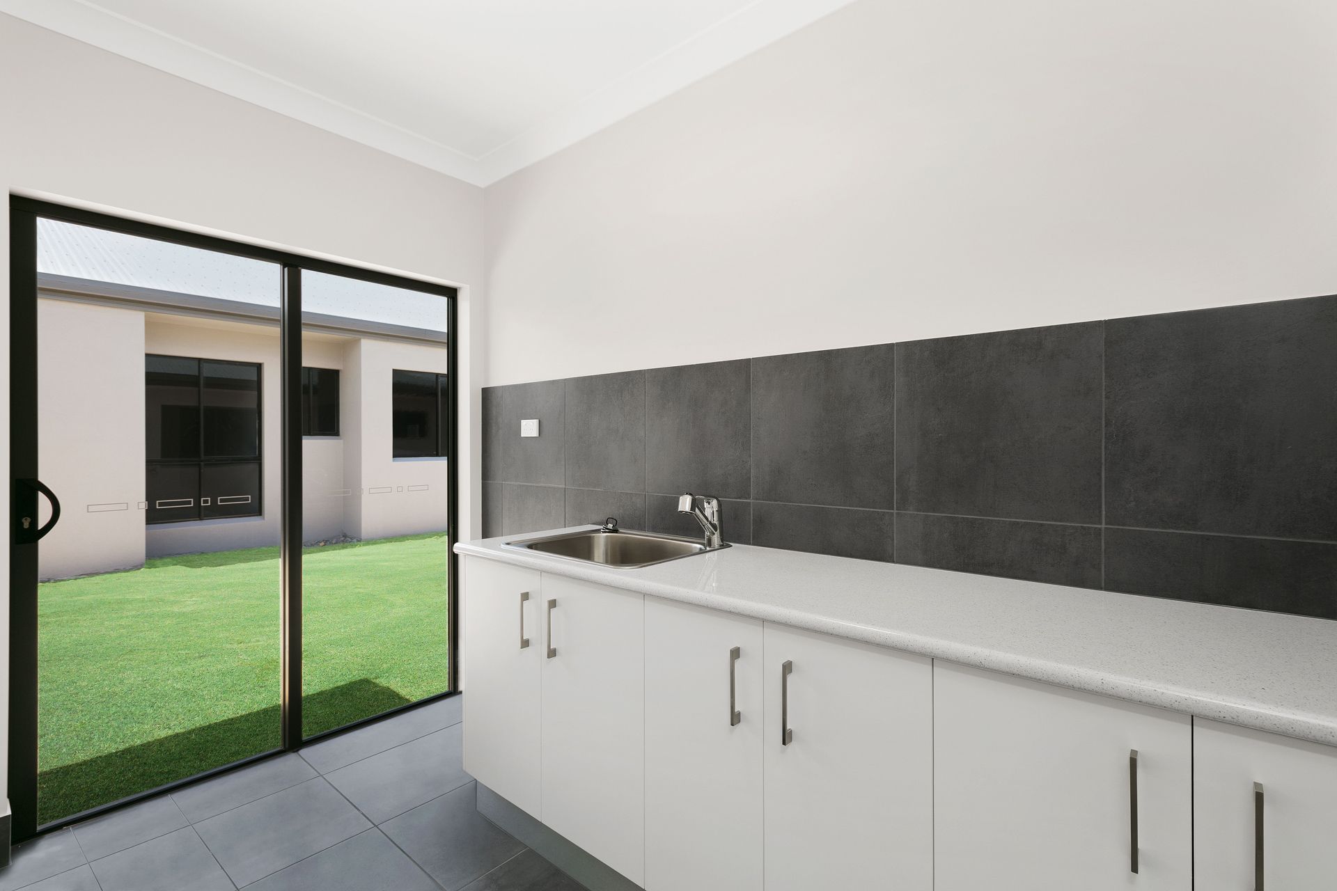A Modern Indoor Kitchenette With White Cabinets — Ashlee Jones Homes in Gordonvale, QLD