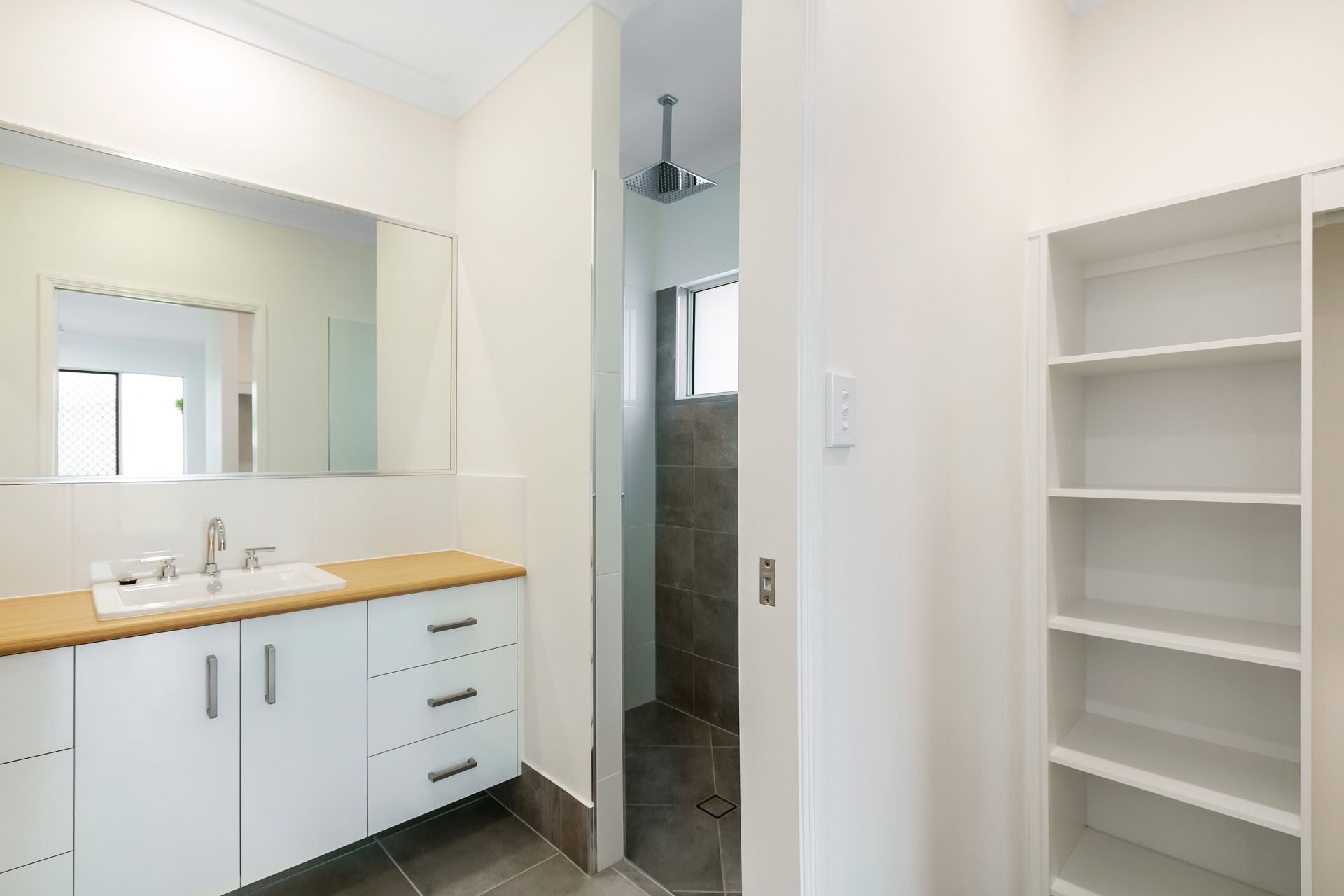 A Modern Bathroom With a White Vanity, a Tiled Shower in an Adjoining Alcove — Ashlee Jones Homes in Gordonvale, QLD