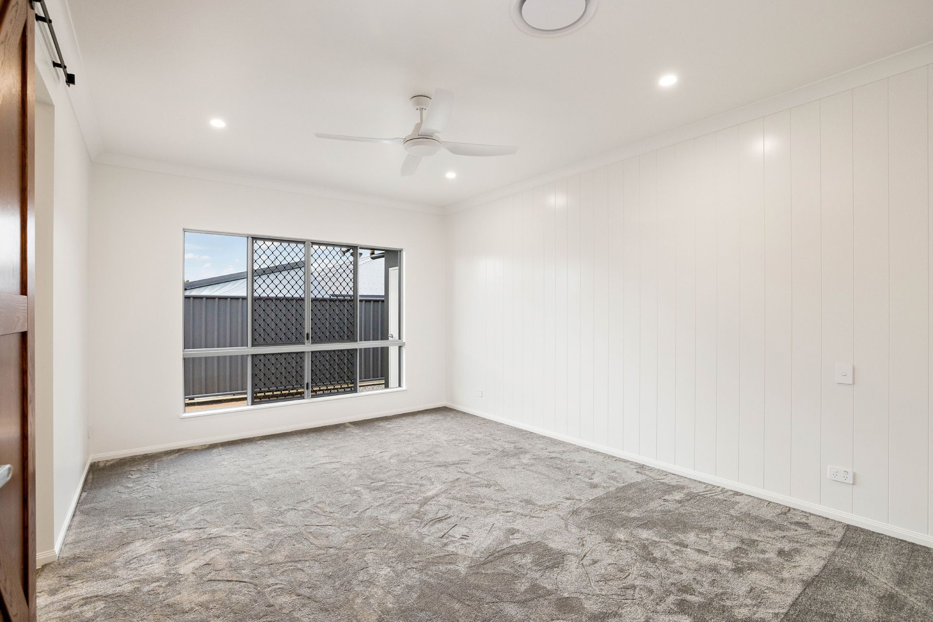 An Empty Bedroom With White Walls, a Large Window — Ashlee Jones Homes in Gordonvale, QLD