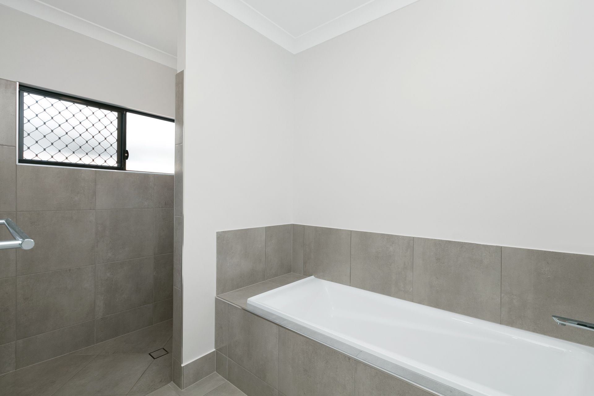 A Modern Bathroom With a Grey-tiled Shower Area — Ashlee Jones Homes in Gordonvale, QLD