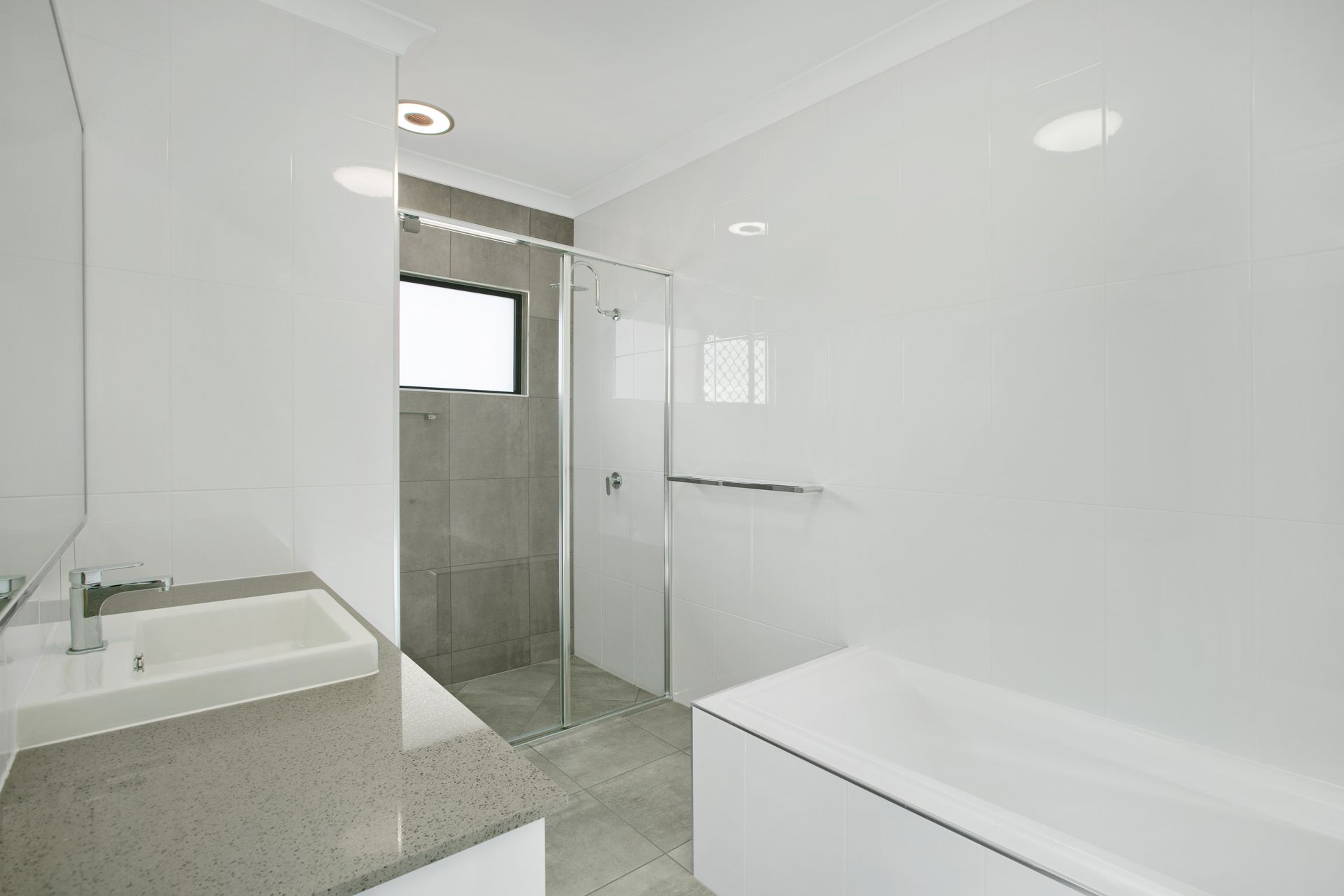 A Modern, Minimalist Bathroom With a White Freestanding Bathtub — Ashlee Jones Homes in Gordonvale, QLD