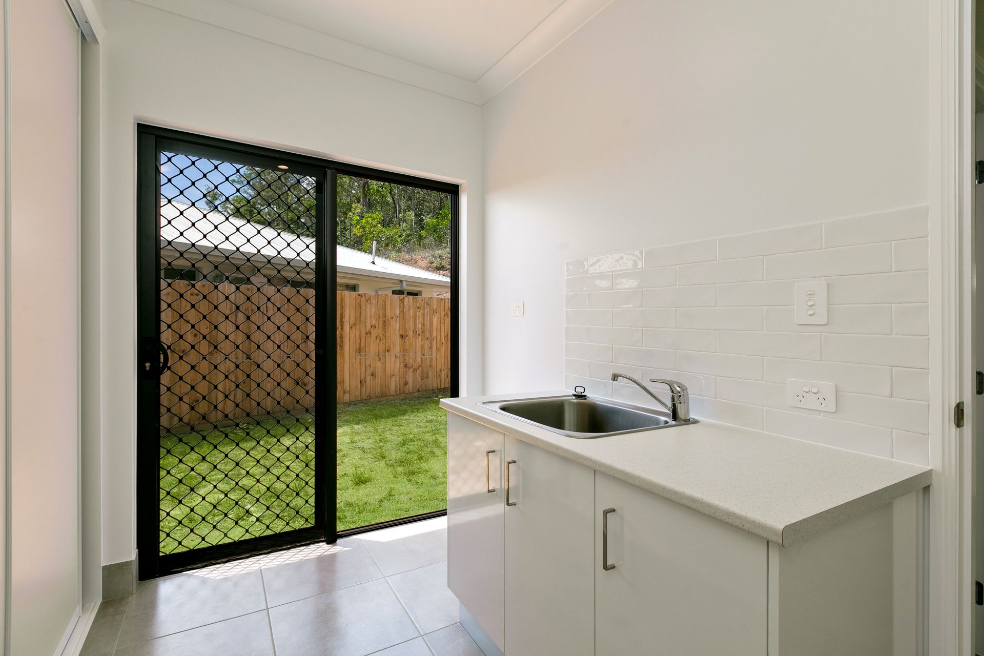 A Bright, Modern Laundry Room With White Cabinets — Ashlee Jones Homes in Gordonvale, QLD