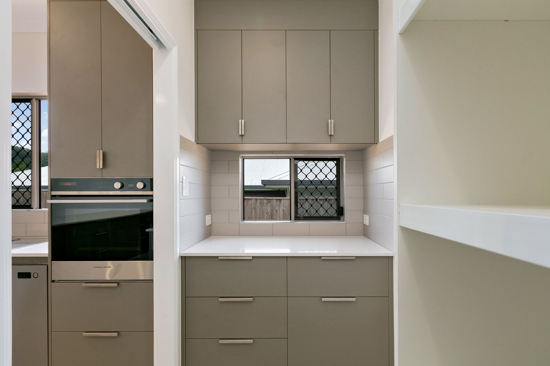 A Modern Kitchen Featuring Matte Taupe Cabinets — Ashlee Jones Homes in Gordonvale, QLD