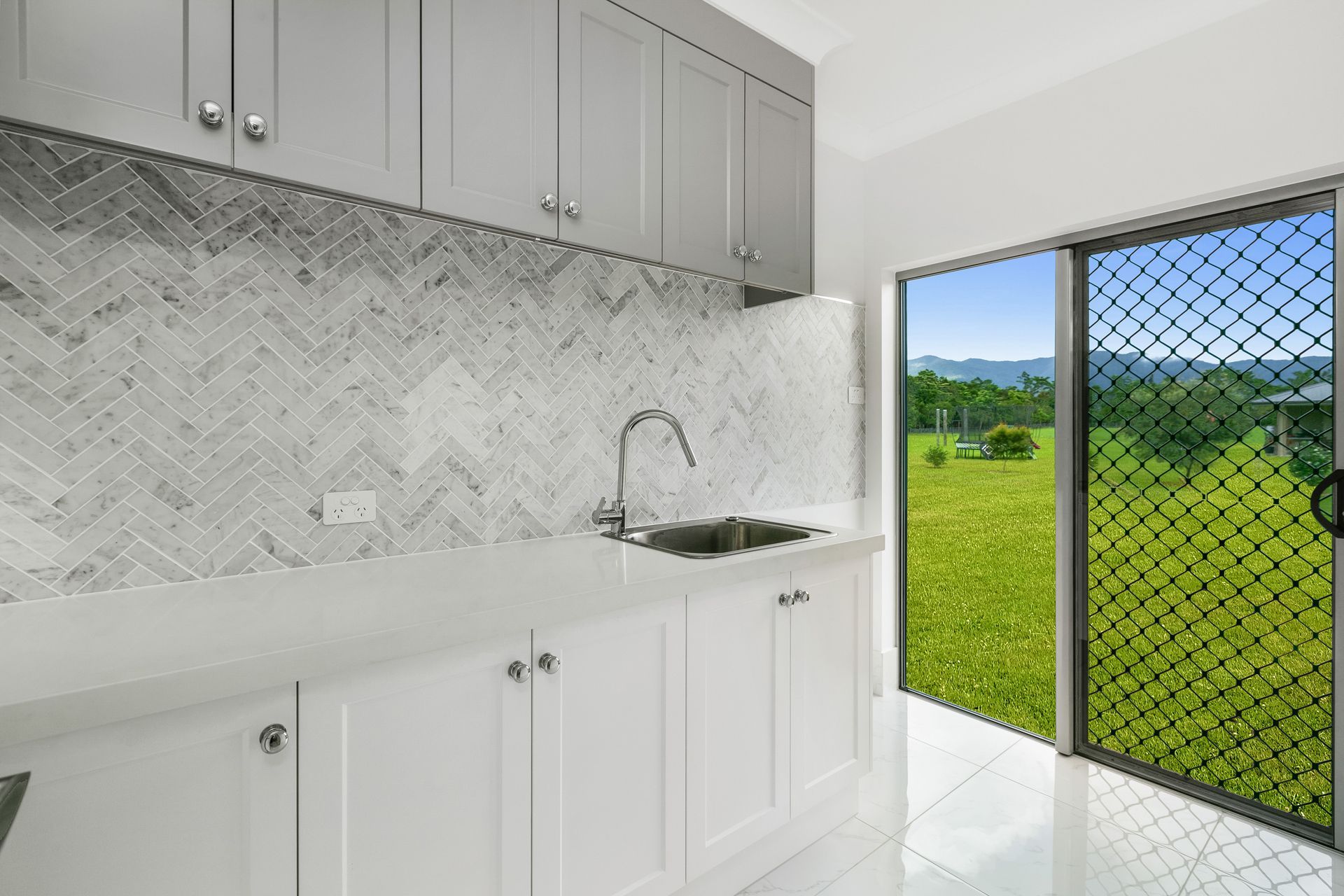 A Kitchen With White Cabinets, a Chevron-patterned Marble Backsplash — Ashlee Jones Homes in Gordonvale, QLD
