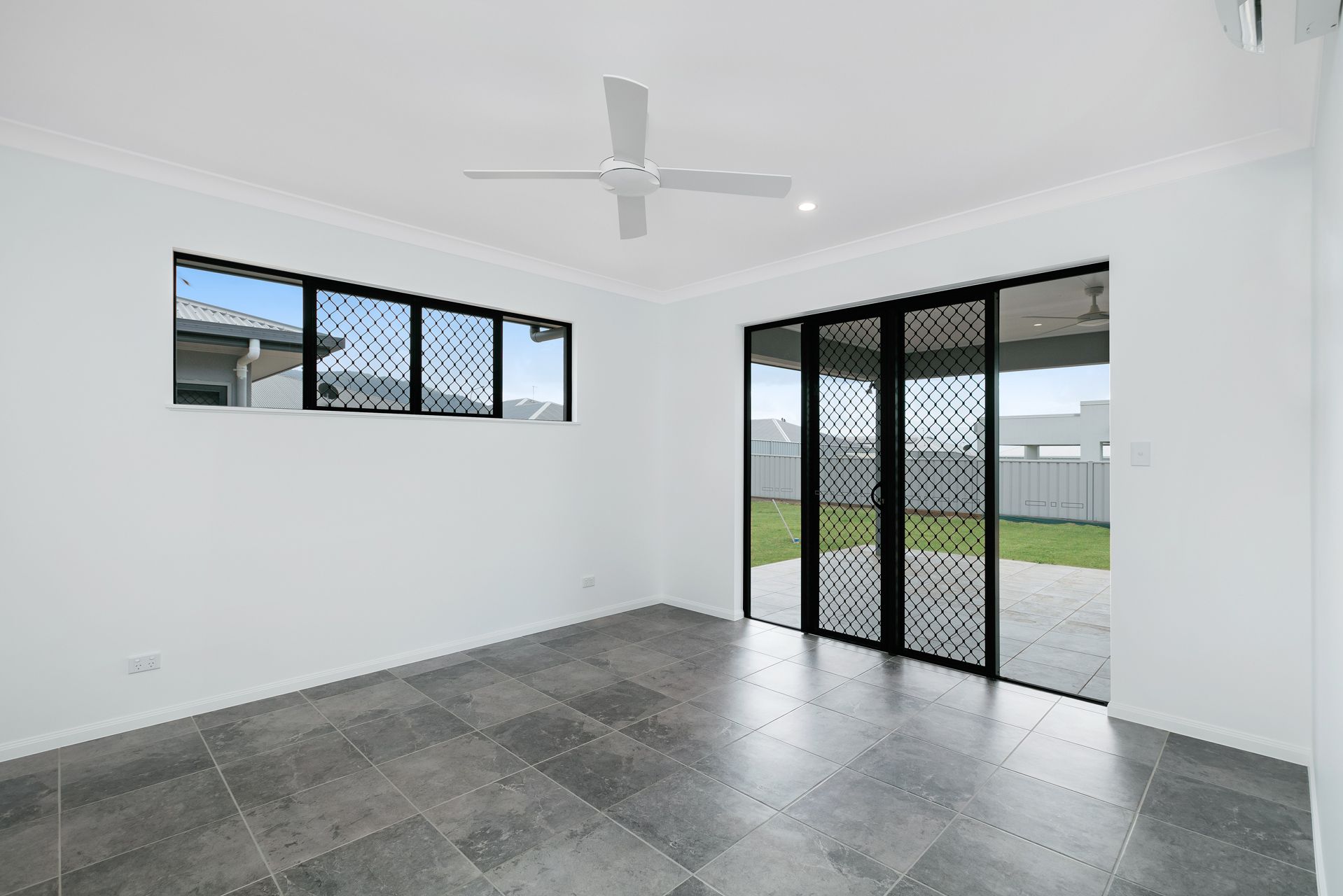 An Empty Room With White Walls, Gray Tile Flooring — Ashlee Jones Homes in Gordonvale, QLD