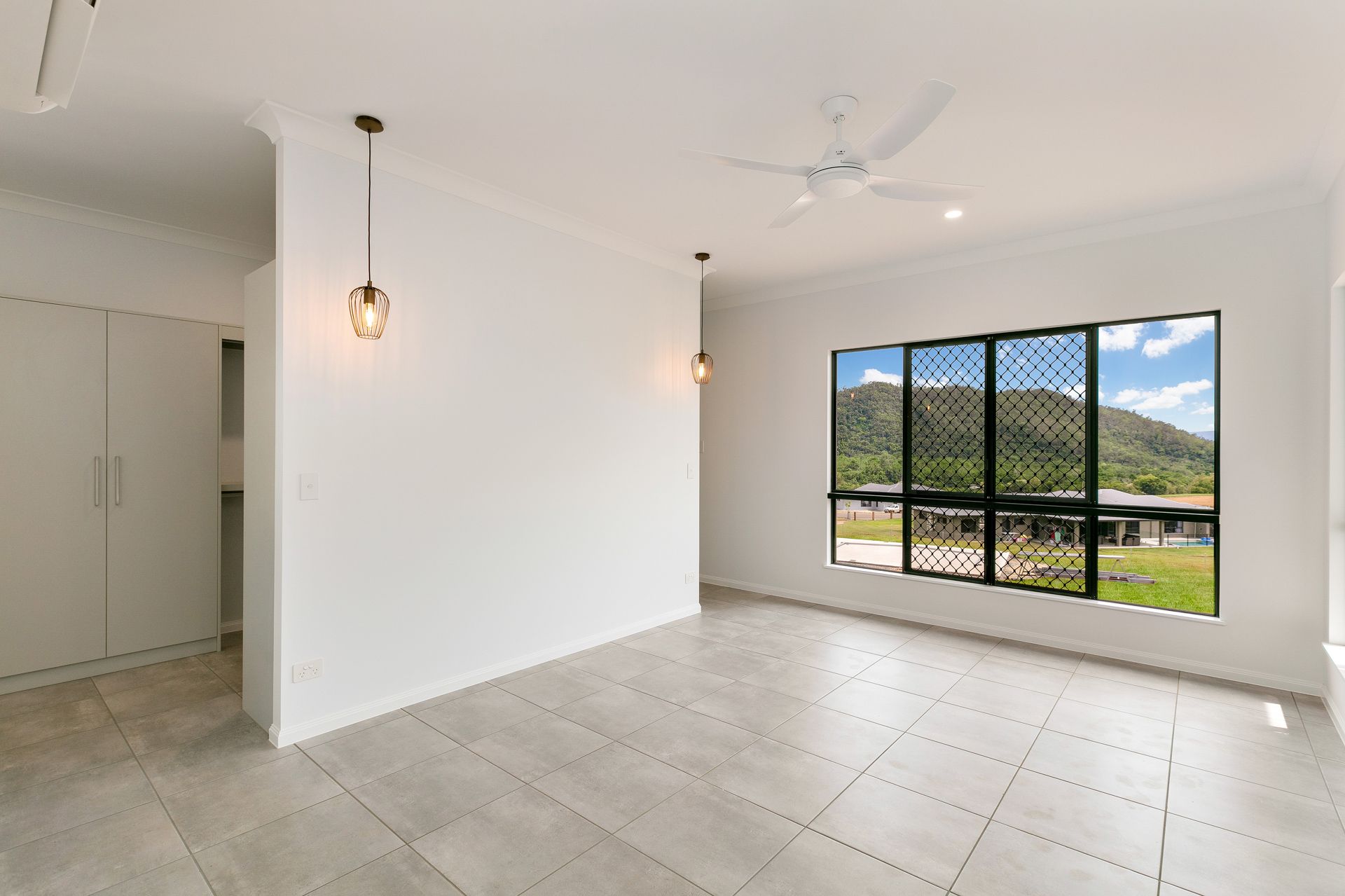 A Bright, Empty Room With White Walls, Light Gray Tile Floors — Ashlee Jones Homes in Gordonvale, QLD