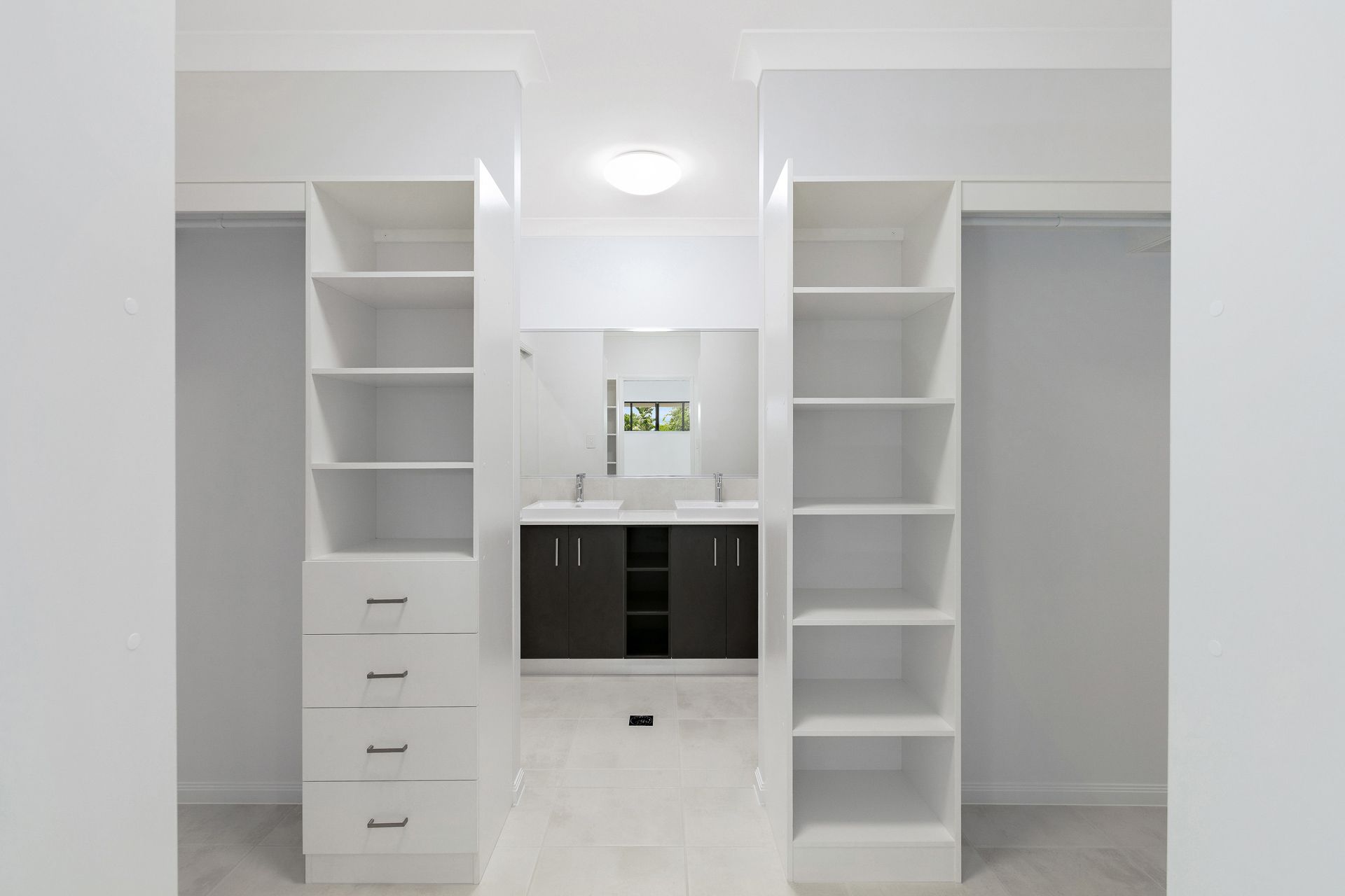 A Symmetrical Hallway Featuring Floor-to-ceiling White Shelving and Drawers — Ashlee Jones Homes in Gordonvale, QLD