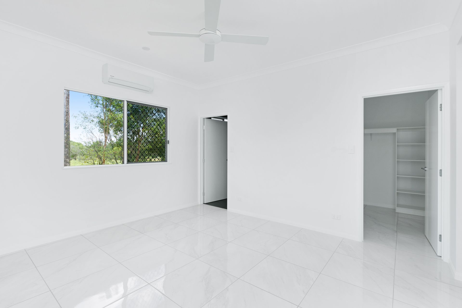 An Empty, White-walled Bedroom Featuring Glossy Tile Floors — Ashlee Jones Homes in Gordonvale, QLD