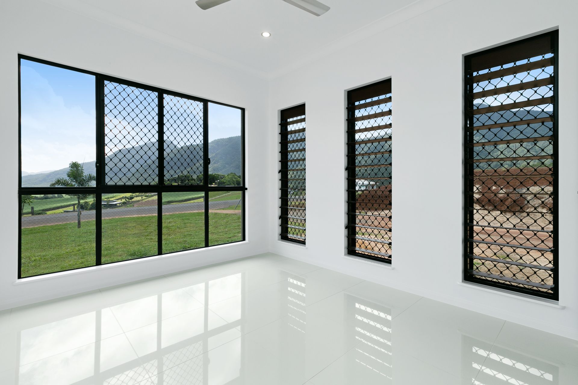 An Empty Room With White Walls, Tiled Floors — Ashlee Jones Homes in Gordonvale, QLD