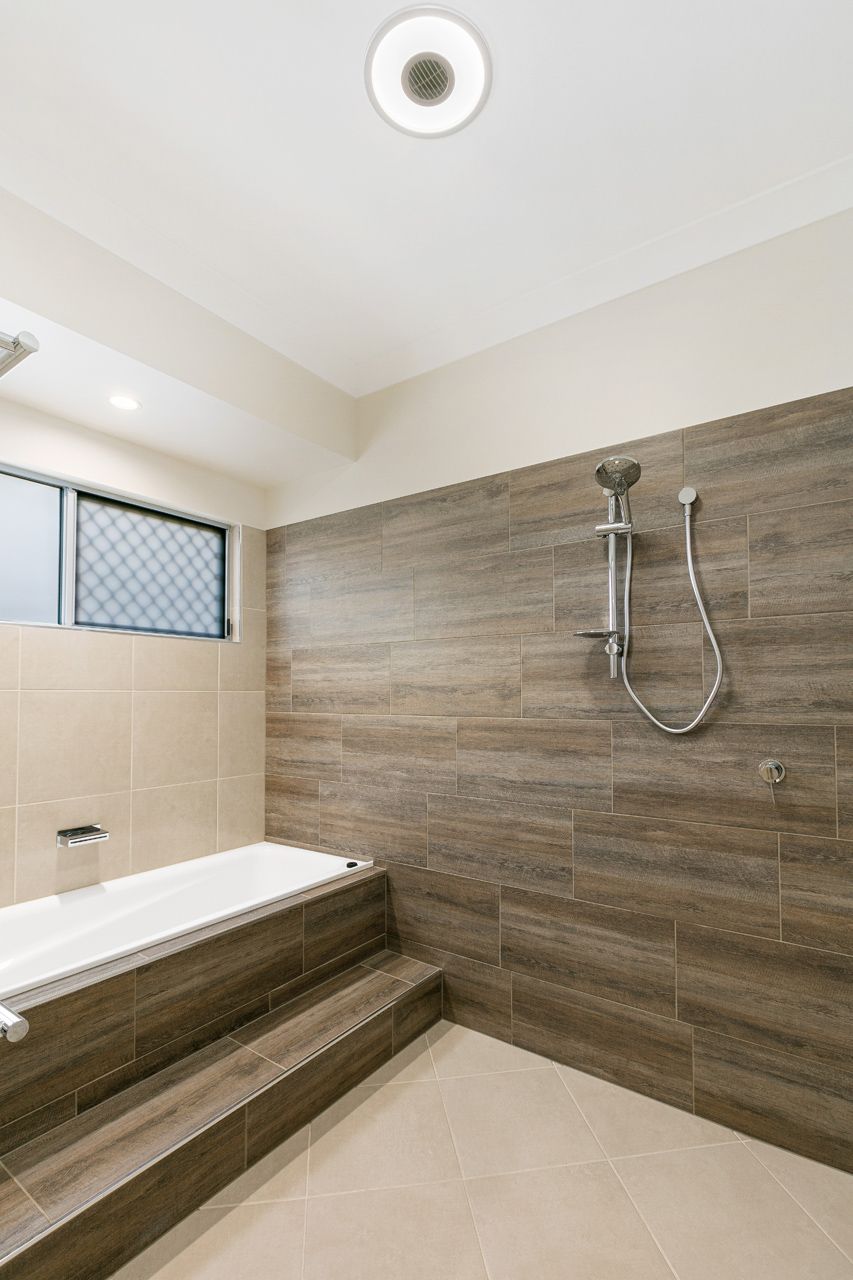 A Modern Bathroom Featuring a White Bathtub — Ashlee Jones Homes in Gordonvale, QLD