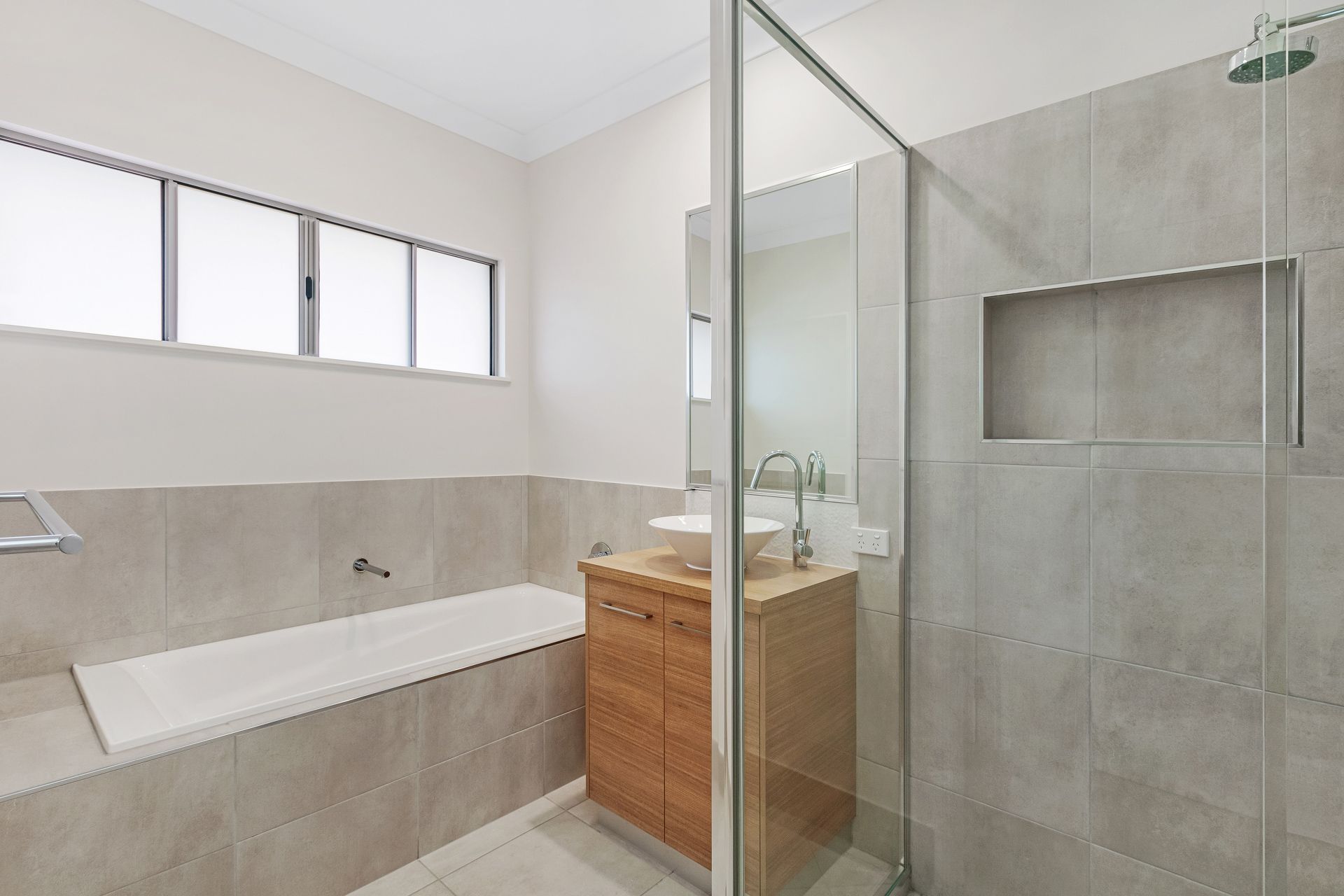 A Modern Bathroom Featuring a White Bathtub — Ashlee Jones Homes in Gordonvale, QLD