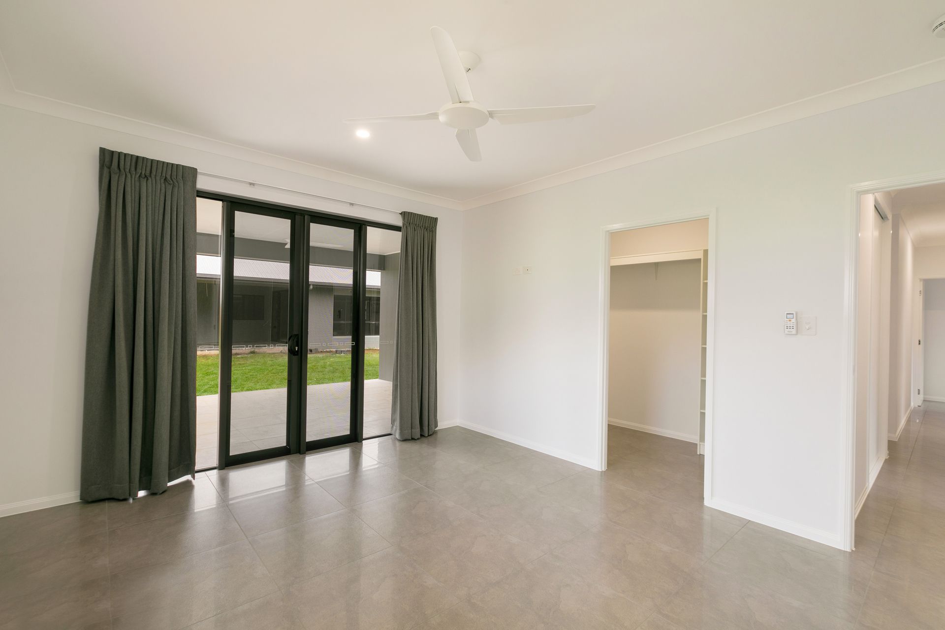 An Empty Living Room With Light Gray Flooring — Ashlee Jones Homes in Gordonvale, QLD