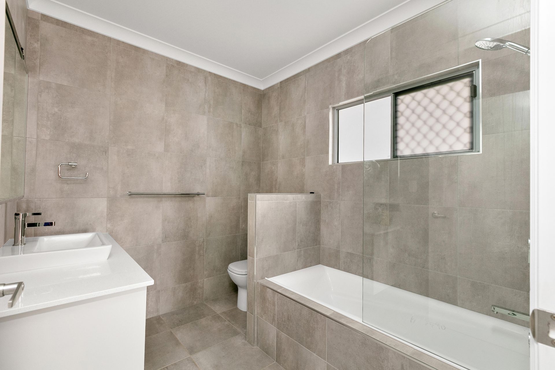 Modern Bathroom With Neutral Gray Tiled Walls — Ashlee Jones Homes in Gordonvale, QLD