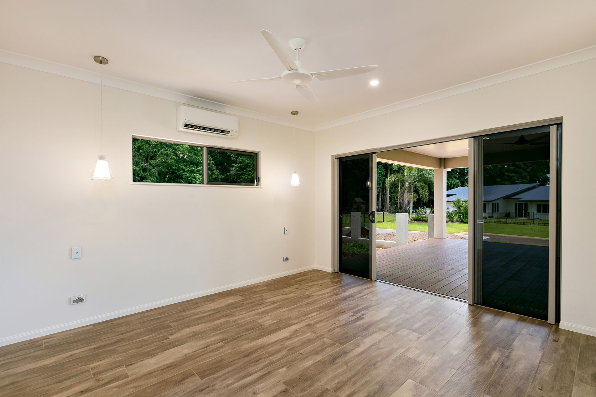 An Empty Room With White Walls, Wood-look Flooring — Ashlee Jones Homes in Gordonvale, QLD