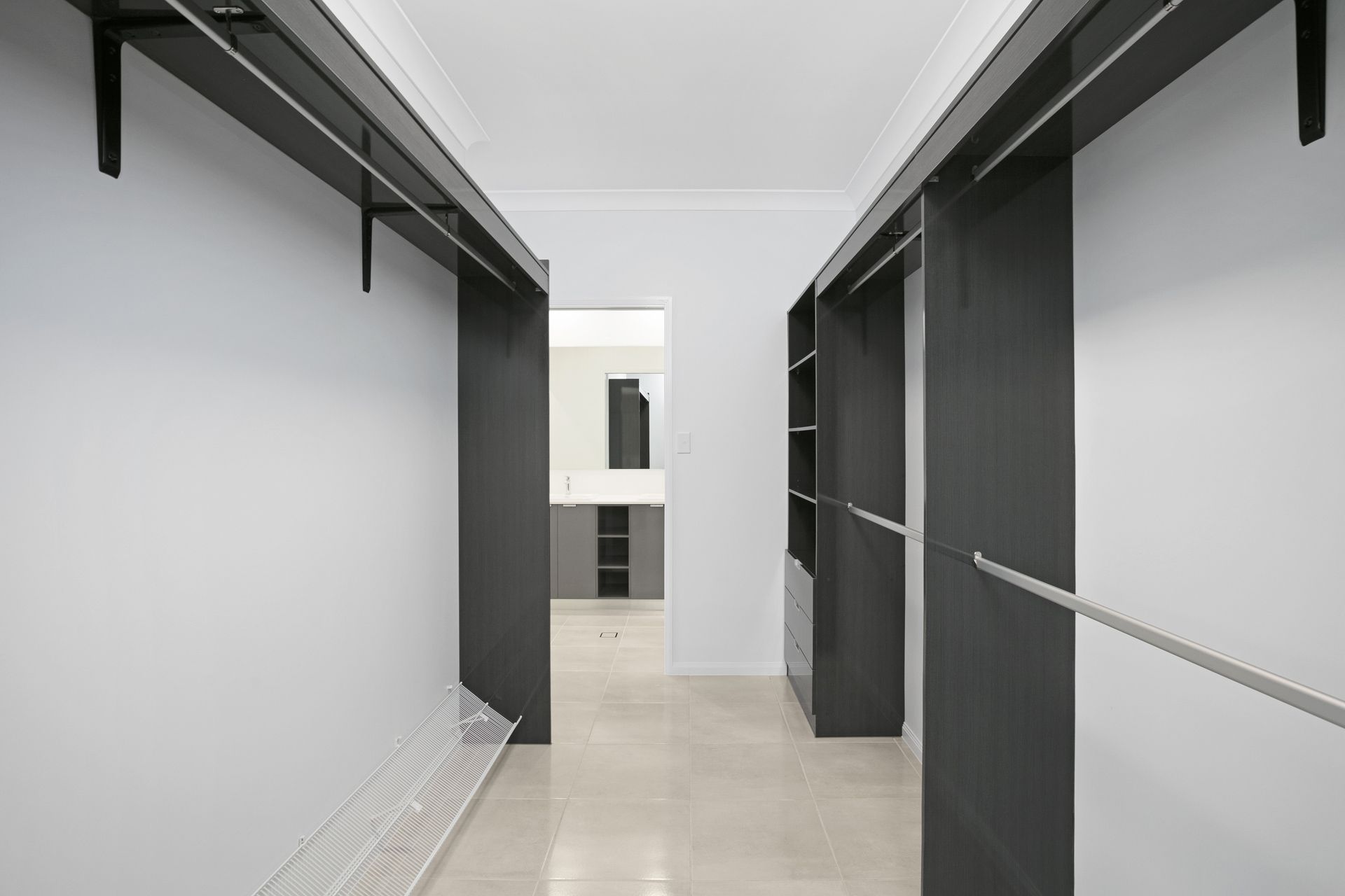 A Walk-in Closet Featuring White Walls, Gray Shelving Units — Ashlee Jones Homes in Gordonvale, QLD