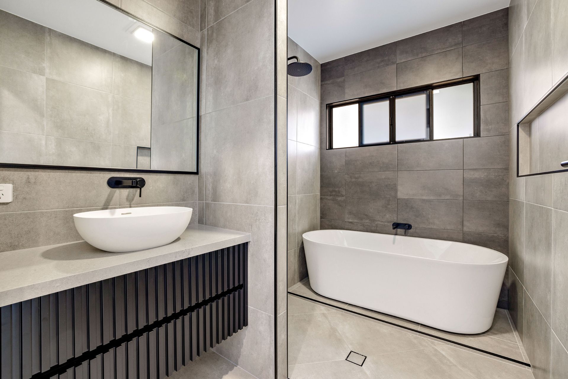 A Modern Bathroom Featuring a White Vessel Sink on a Dark Vanity — Ashlee Jones Homes in Gordonvale, QLD