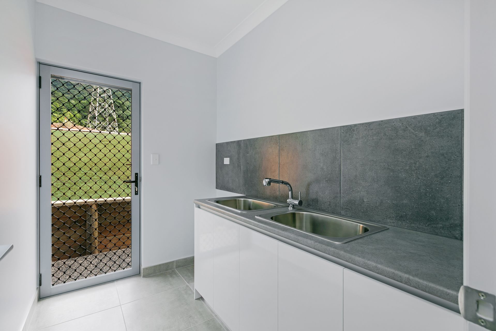 A Modern Kitchen Area Featuring White Cabinets — Ashlee Jones Homes in Gordonvale, QLD