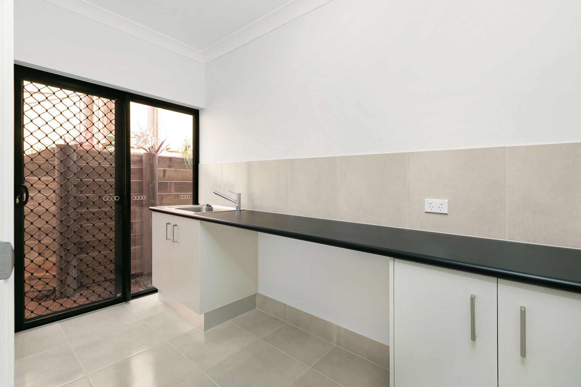 A Modern Laundry Room With White Cabinets — Ashlee Jones Homes in Gordonvale, QLD