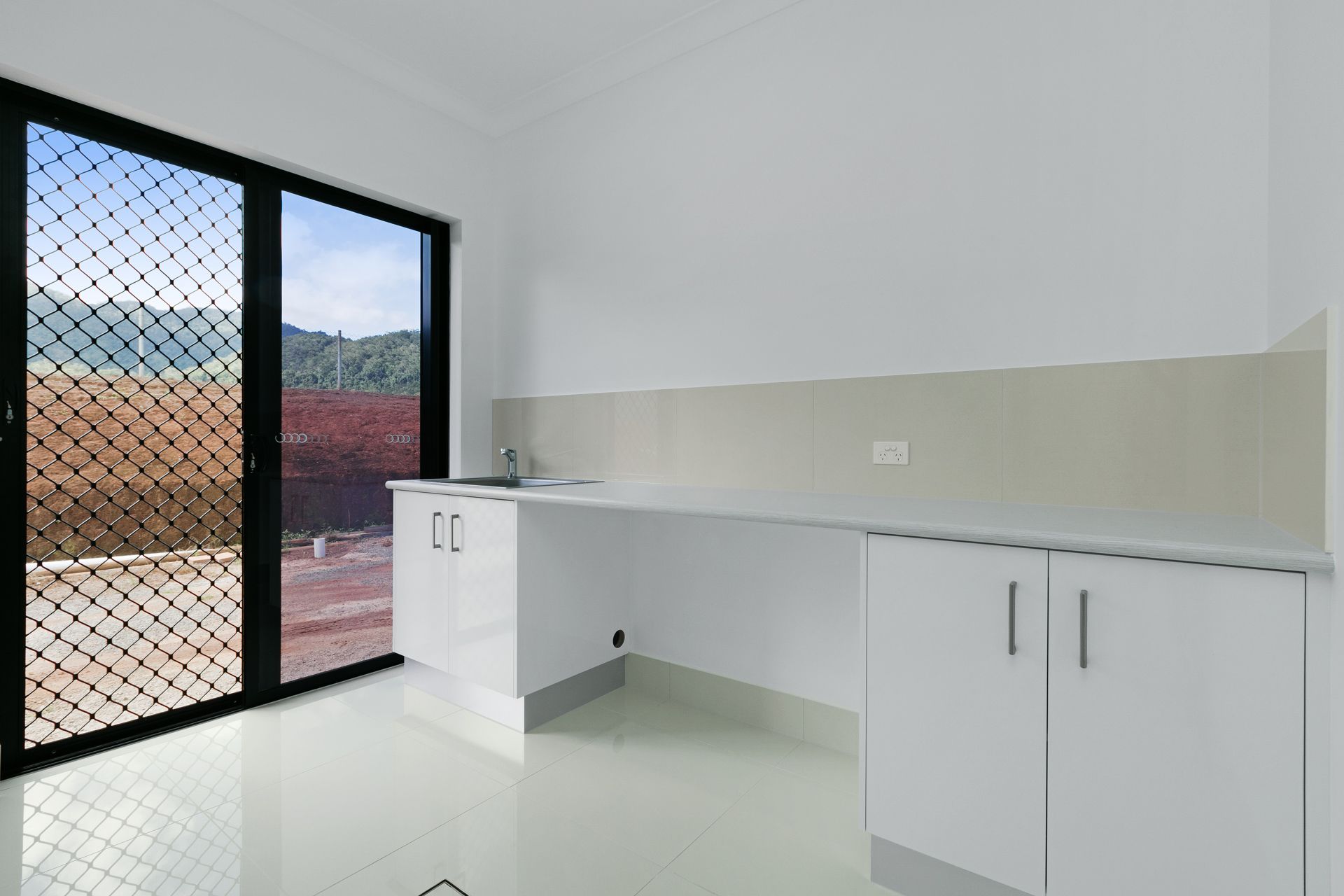 Modern Kitchenette With White Cabinets, White Tiled Floors — Ashlee Jones Homes in Gordonvale, QLD