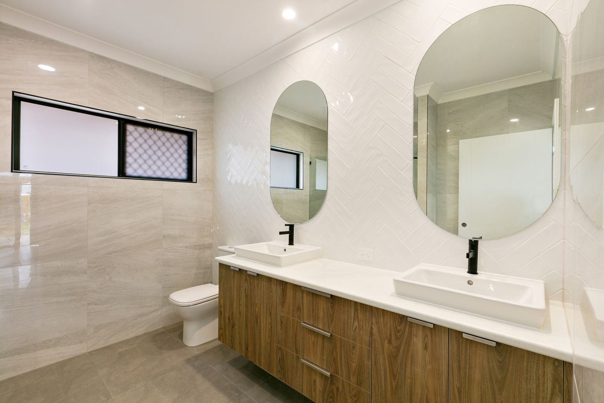 A Modern Bathroom With a Wood-toned Double Vanity — Ashlee Jones Homes in Gordonvale, QLD