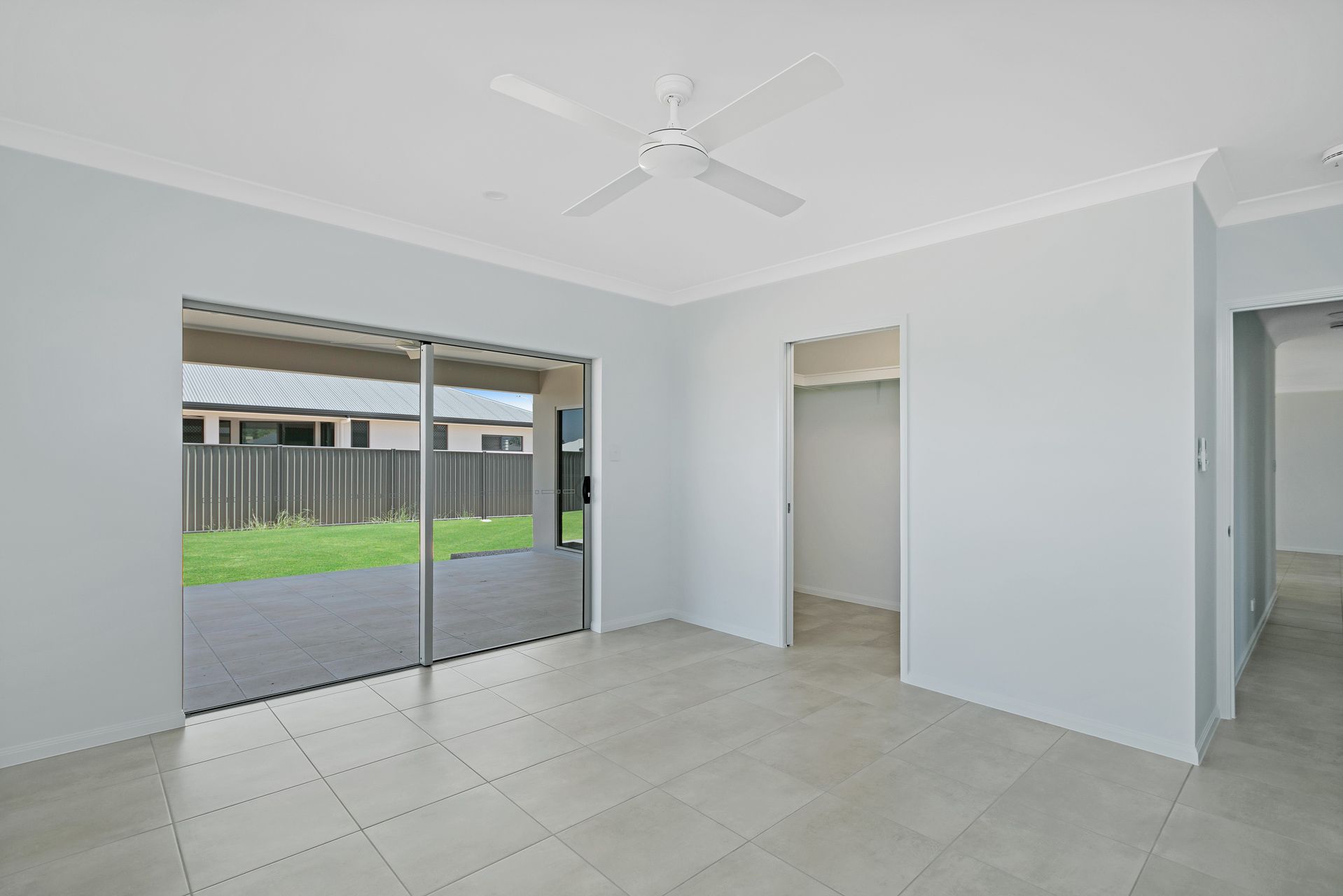 A Bright, Empty Room With Light Grey Tile Floors, White Walls — Ashlee Jones Homes in Gordonvale, QLD