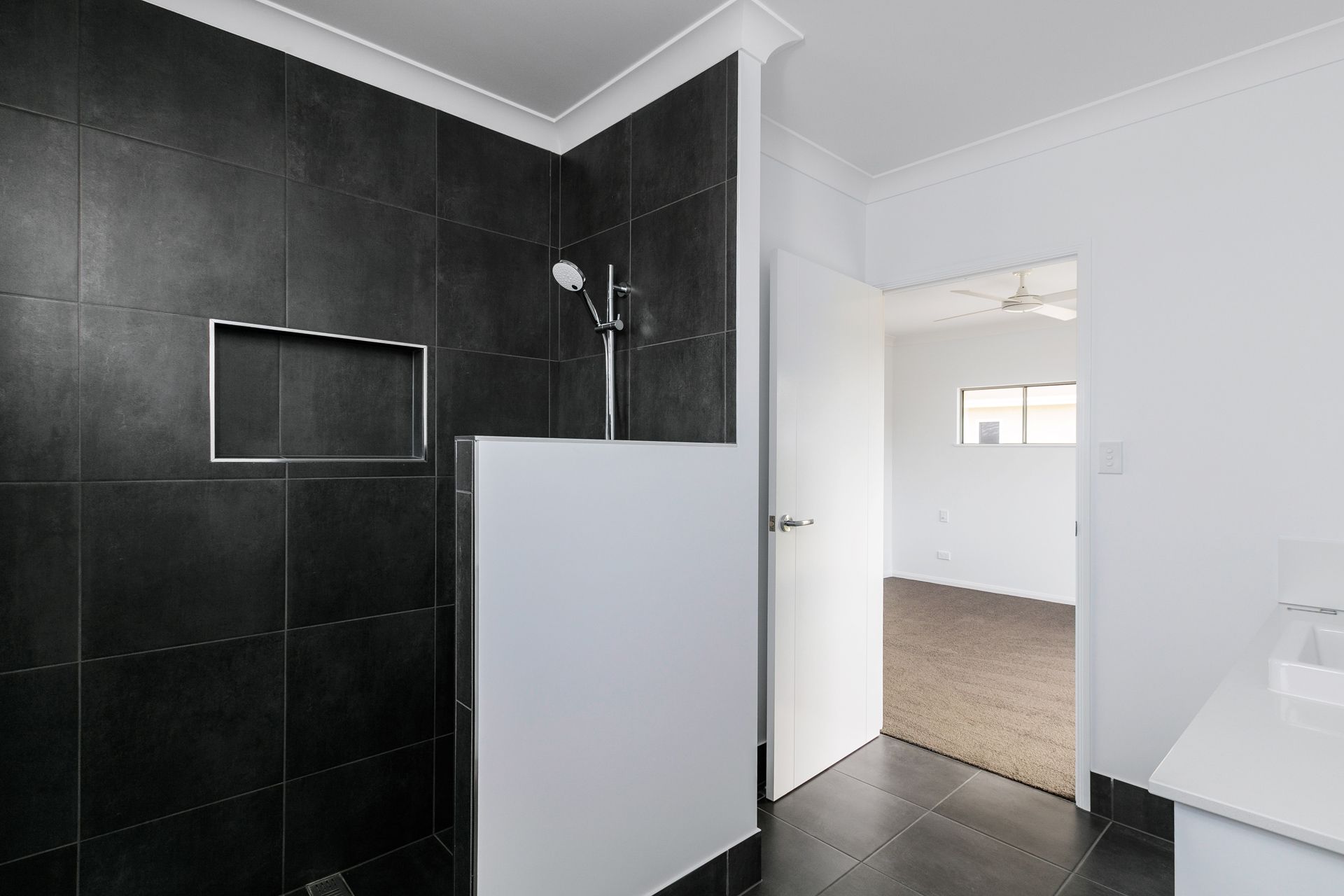 A Modern Shower With Dark Grey Tiles and a Built-in Wall Niche — Ashlee Jones Homes in Gordonvale, QLD