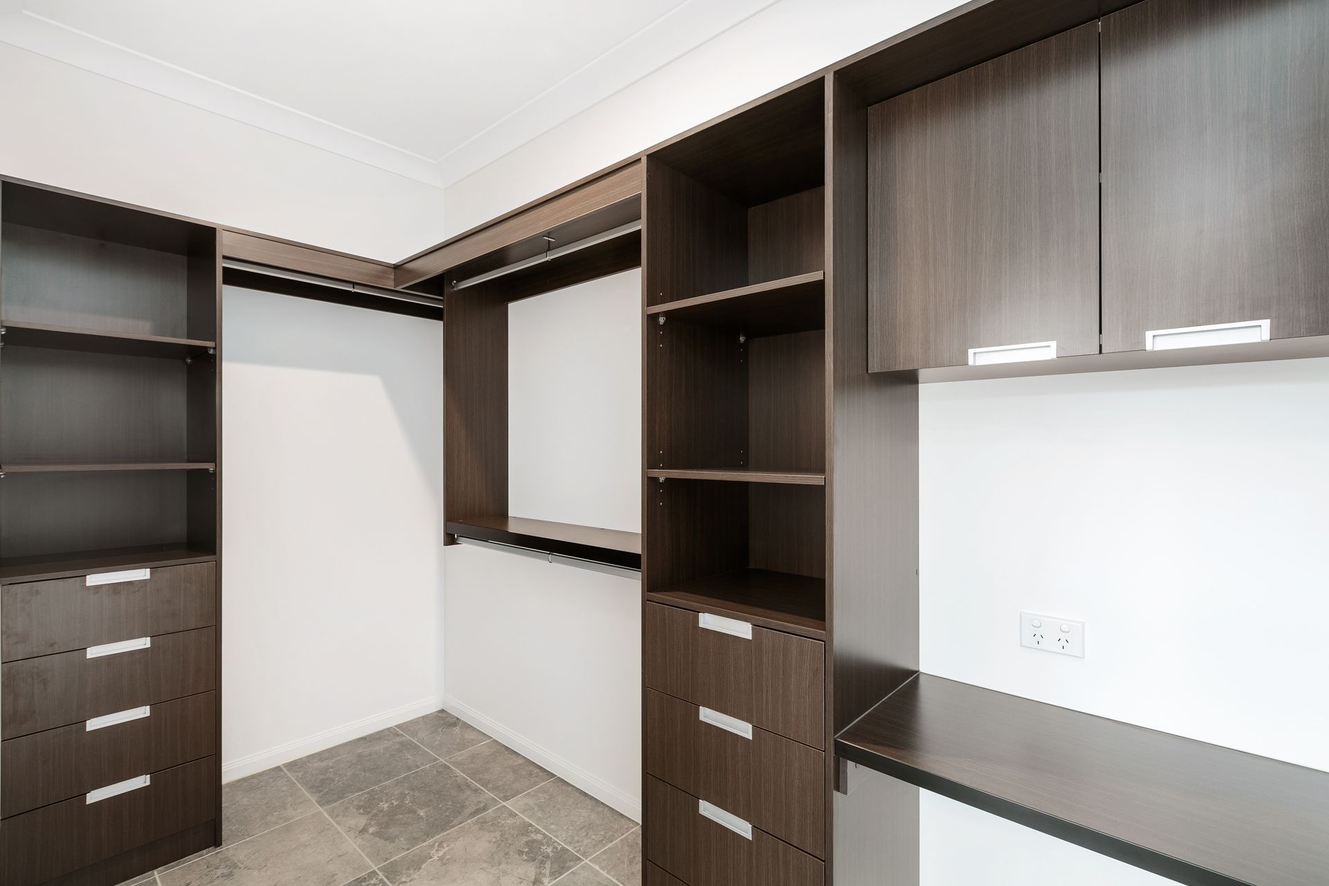 A Walk-in Closet Featuring Dark Wood Cabinetry — Ashlee Jones Homes in Gordonvale, QLD