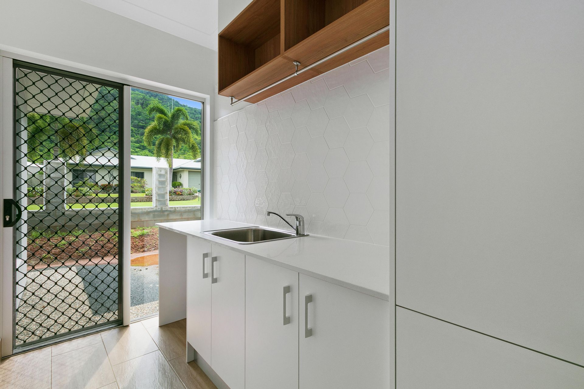 A Modern Kitchen Featuring White Cabinets — Ashlee Jones Homes in Gordonvale, QLD