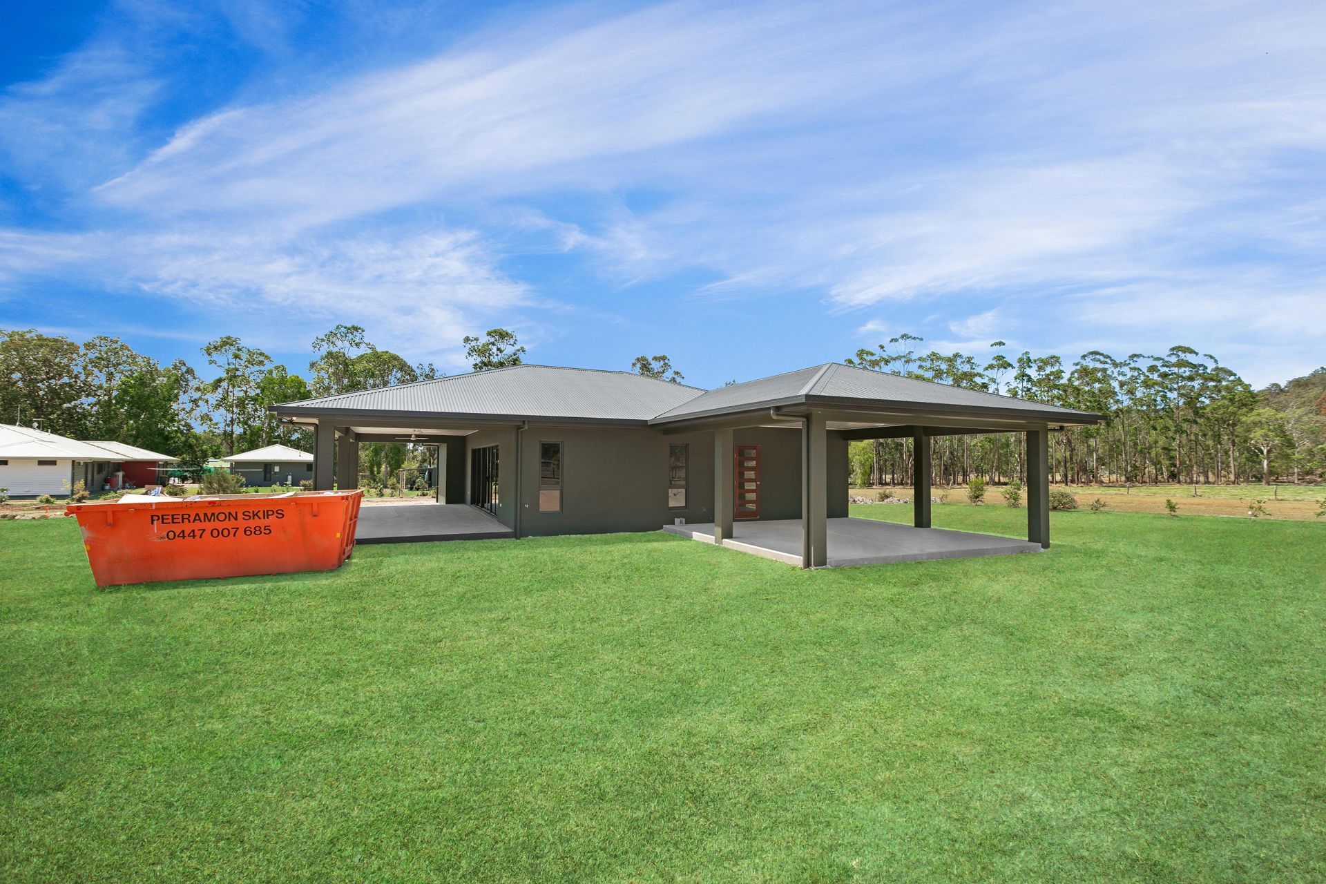 A Modern, Dark-gray House With a Carport and Patio Sits — Ashlee Jones Homes in Gordonvale, QLD