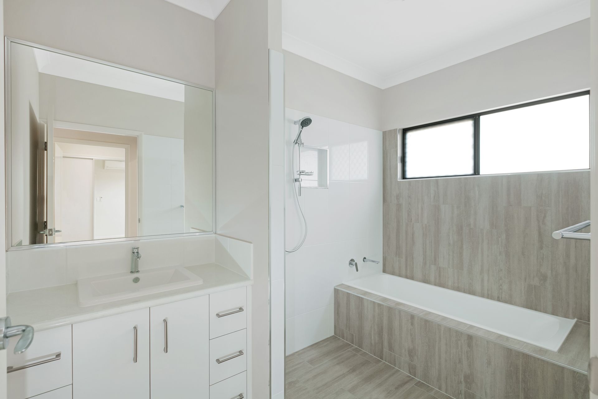 A Modern Bathroom Featuring a White Vanity With a Rectangular Sink — Ashlee Jones Homes in Gordonvale, QLD