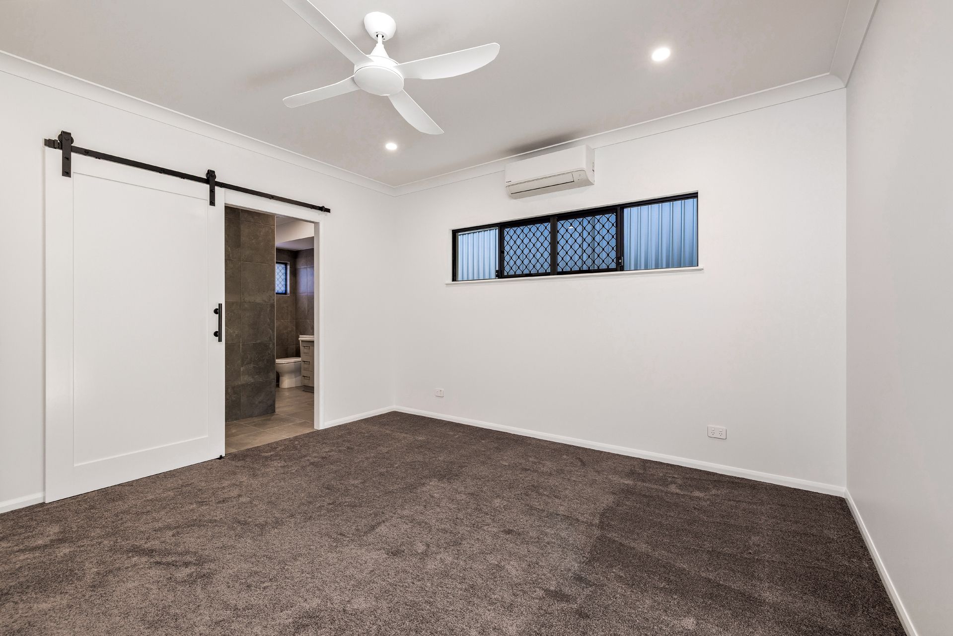 A Bright, Empty Bedroom With White Walls — Ashlee Jones Homes in Gordonvale, QLD