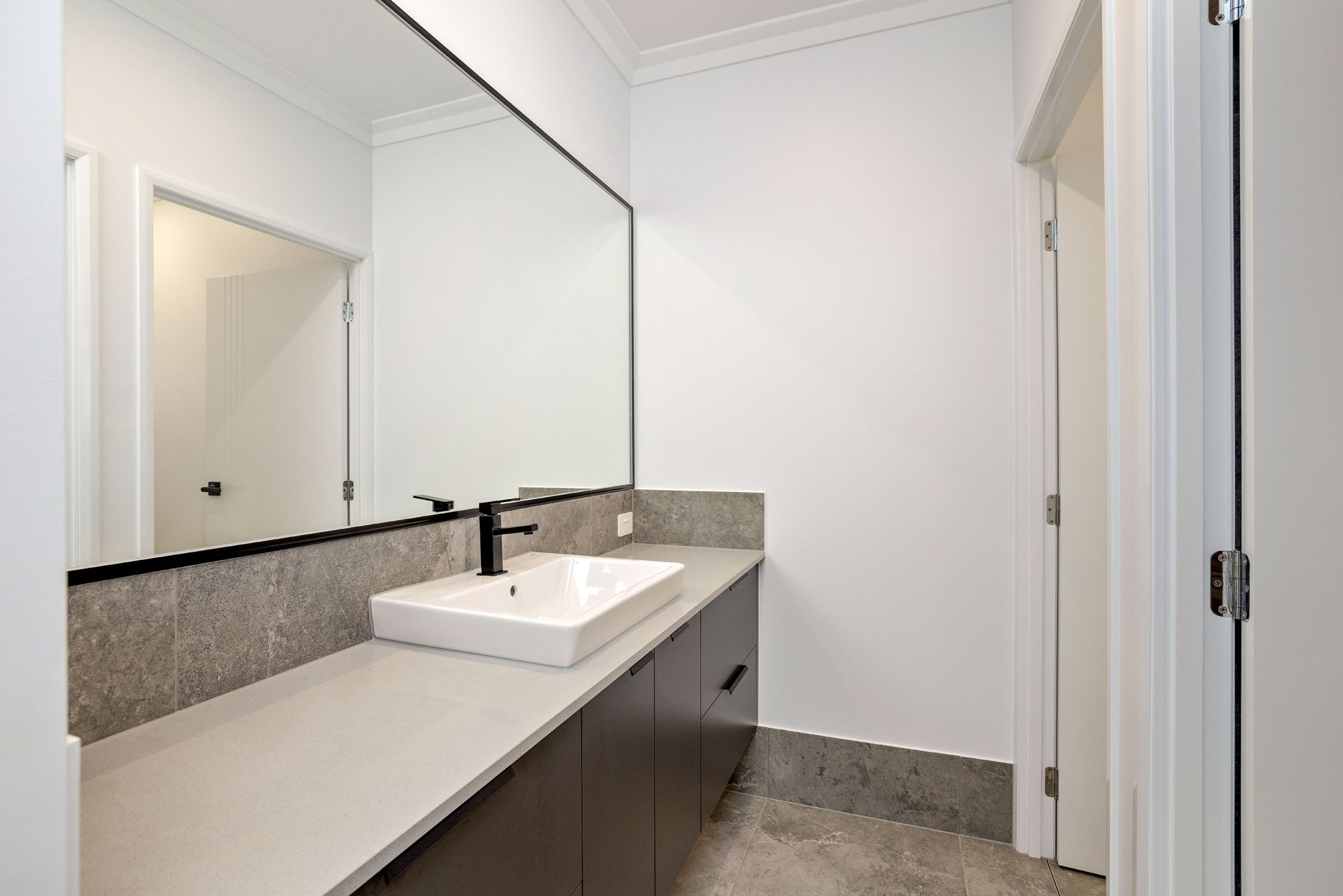 Modern Bathroom Featuring a Dark Wood Vanity — Ashlee Jones Homes in Gordonvale, QLD