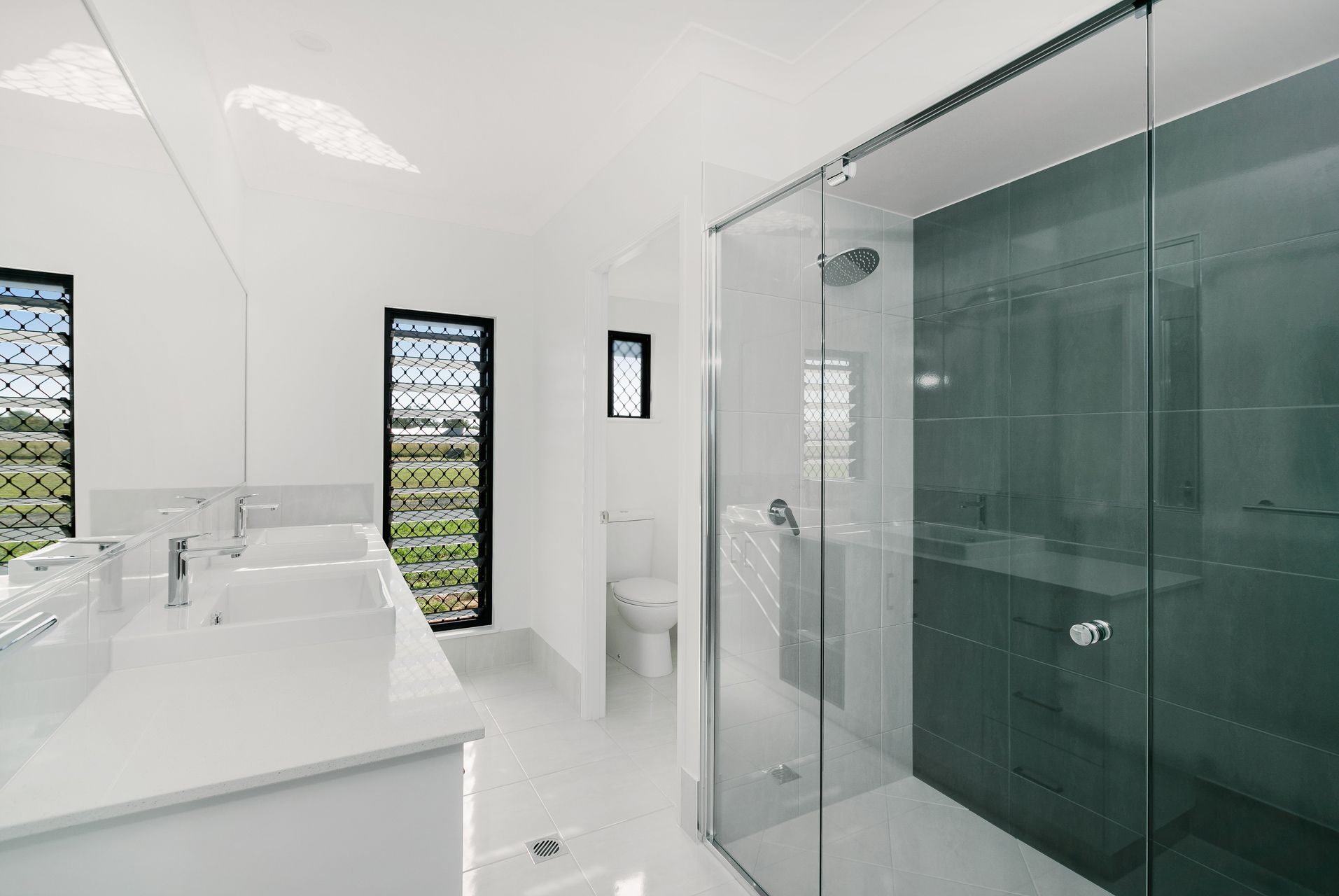 A Modern White Bathroom With a Double Vanity — Ashlee Jones Homes in Gordonvale, QLD