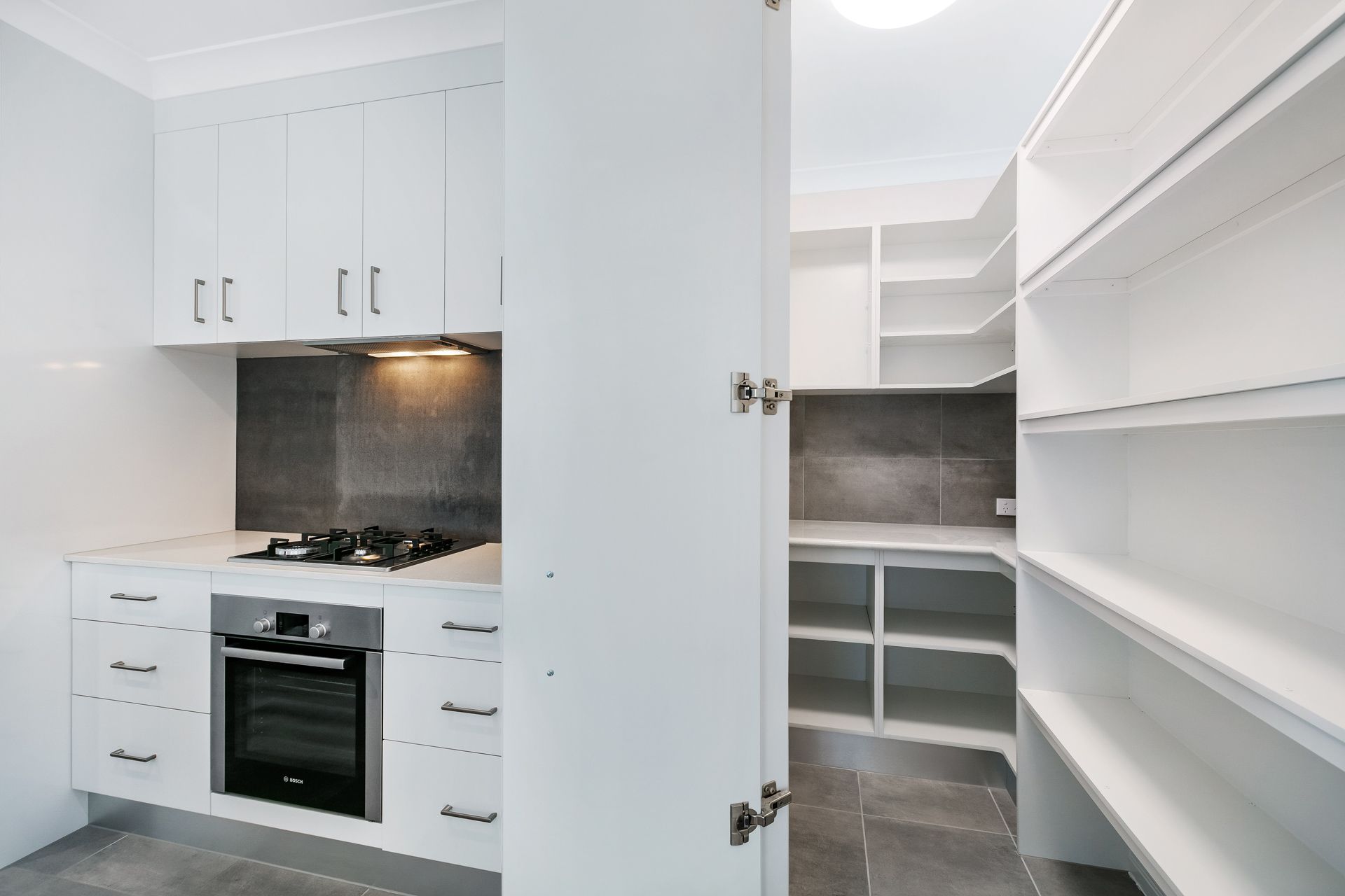 Modern Kitchen With White Cabinets, Stainless Steel Oven — Ashlee Jones Homes in Gordonvale, QLD