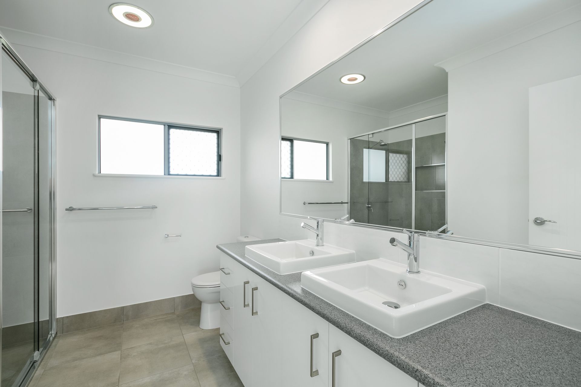 Modern, White Bathroom With a Double Sink Vanity — Ashlee Jones Homes in Gordonvale, QLD