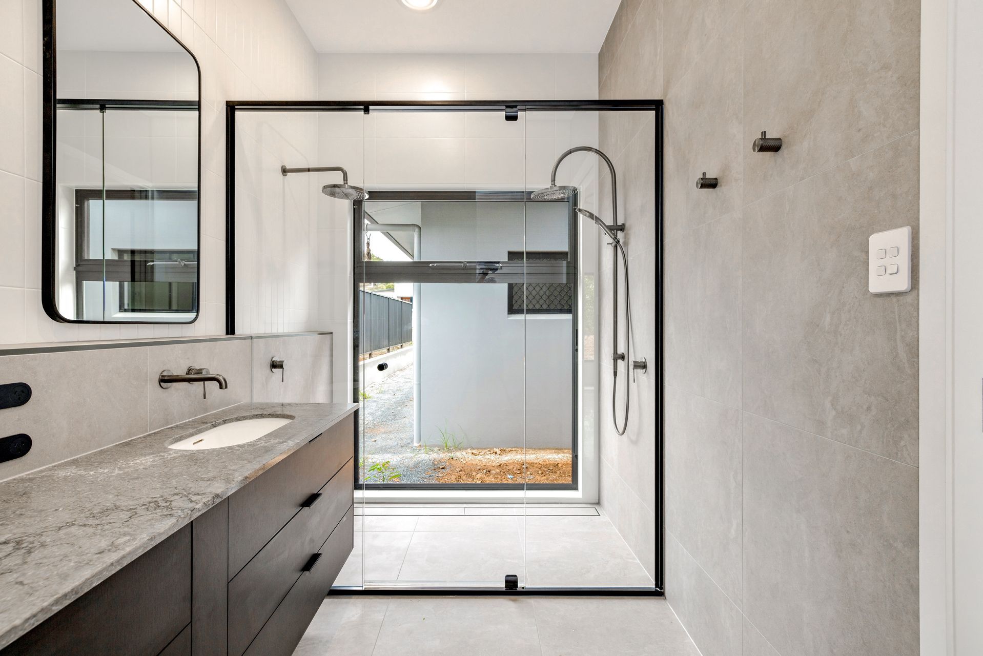 A Modern Bathroom With a Dark Wood Vanity — Ashlee Jones Homes in Gordonvale, QLD